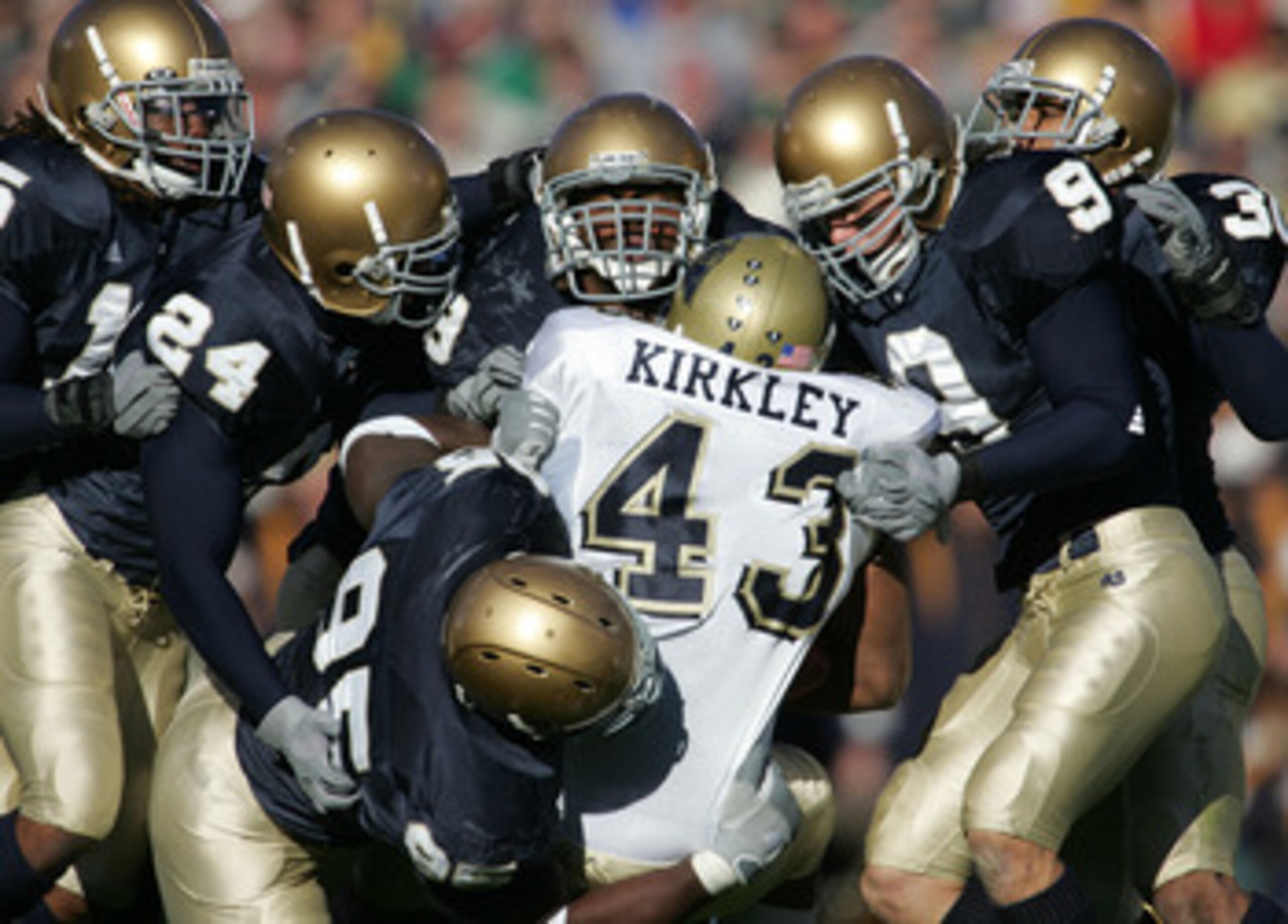 SOUTH BEND, IN - NOVEMBER 13:  Defensive members of Notre Dame including end Victor Abiamiri #95, cornerback Dwight Ellick #24, safety Tom Zbikowski #9 and linebacker Derek Curry #49 stop tailback Raymond Kirkley #43 of Pittsburgh on November 13, 2004 at