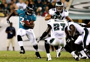 PHILADELPHIA, PA - AUGUST 27:  Chauncey Washington #34 of the Jacksonville Jaguars runs the ball against Quinton Mikell #27 of the Philadelphia Eagles during the preseason game at Lincoln Financial Field on August 27, 2009 in Philadelphia, Pennsylvania.  