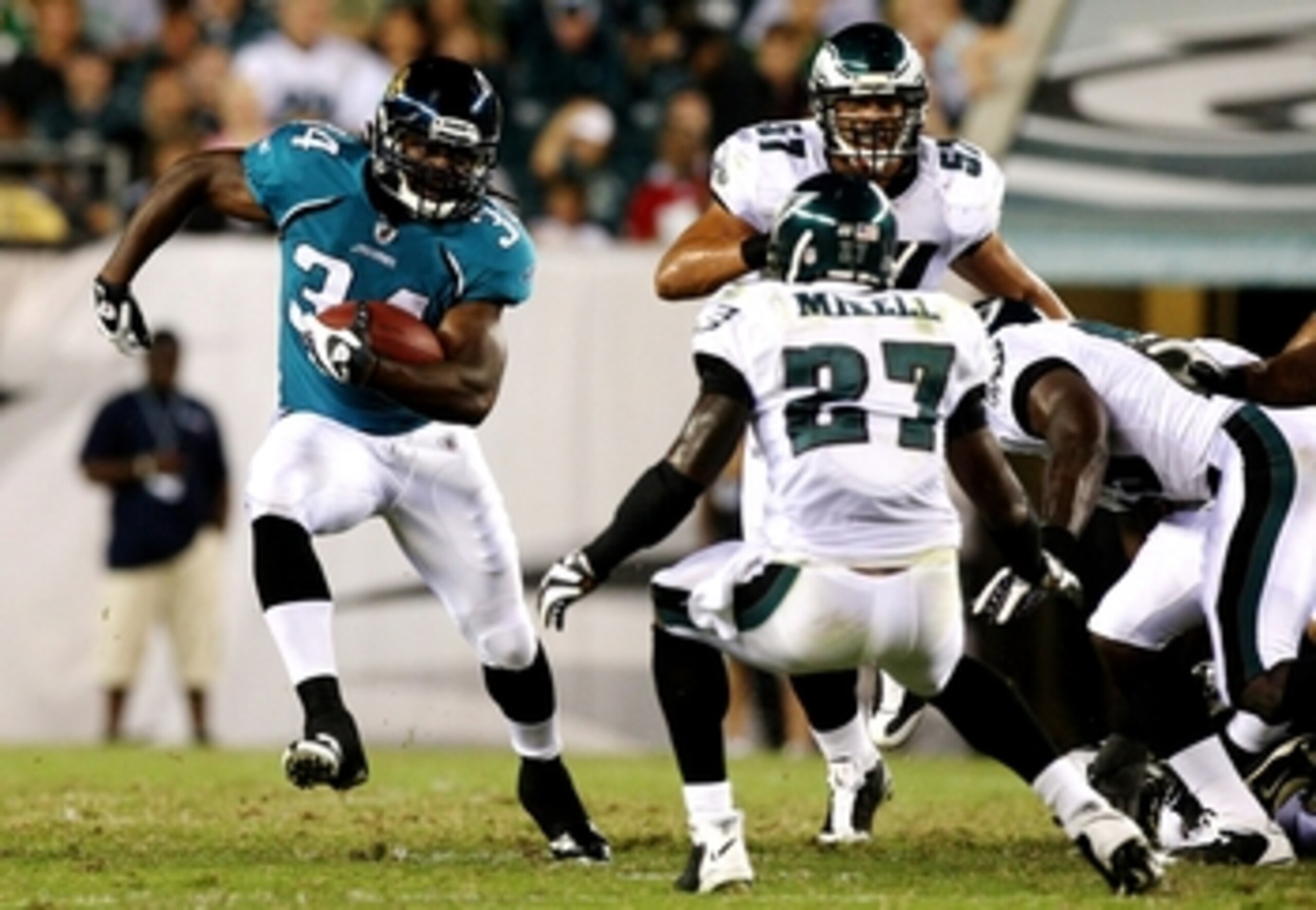 PHILADELPHIA, PA - AUGUST 27:  Chauncey Washington #34 of the Jacksonville Jaguars runs the ball against Quinton Mikell #27 of the Philadelphia Eagles during the preseason game at Lincoln Financial Field on August 27, 2009 in Philadelphia, Pennsylvania.  