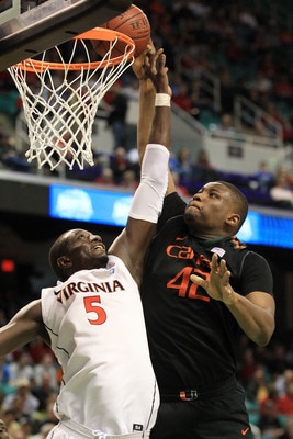 GREENSBORO, NC - MARCH 10:  Reggie Johnson #42 of the Miami Hurricanes shoots against Assane Sene #5 of the Virginia Cavaliers during the second half of the game in the first round of the 2011 ACC men's basketball tournament at the Greensboro Coliseum on