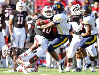LOUISVILLE, KY - NOVEMBER 20:  Dominique Brown #10 of the Louisville Cardinals is tackled by Doug Rigg #47 of the West Virginia Mountaineers during the game at Papa John's Cardinal Stadium on November 20, 2010 in Louisville, Kentucky.  (Photo by Andy Lyon