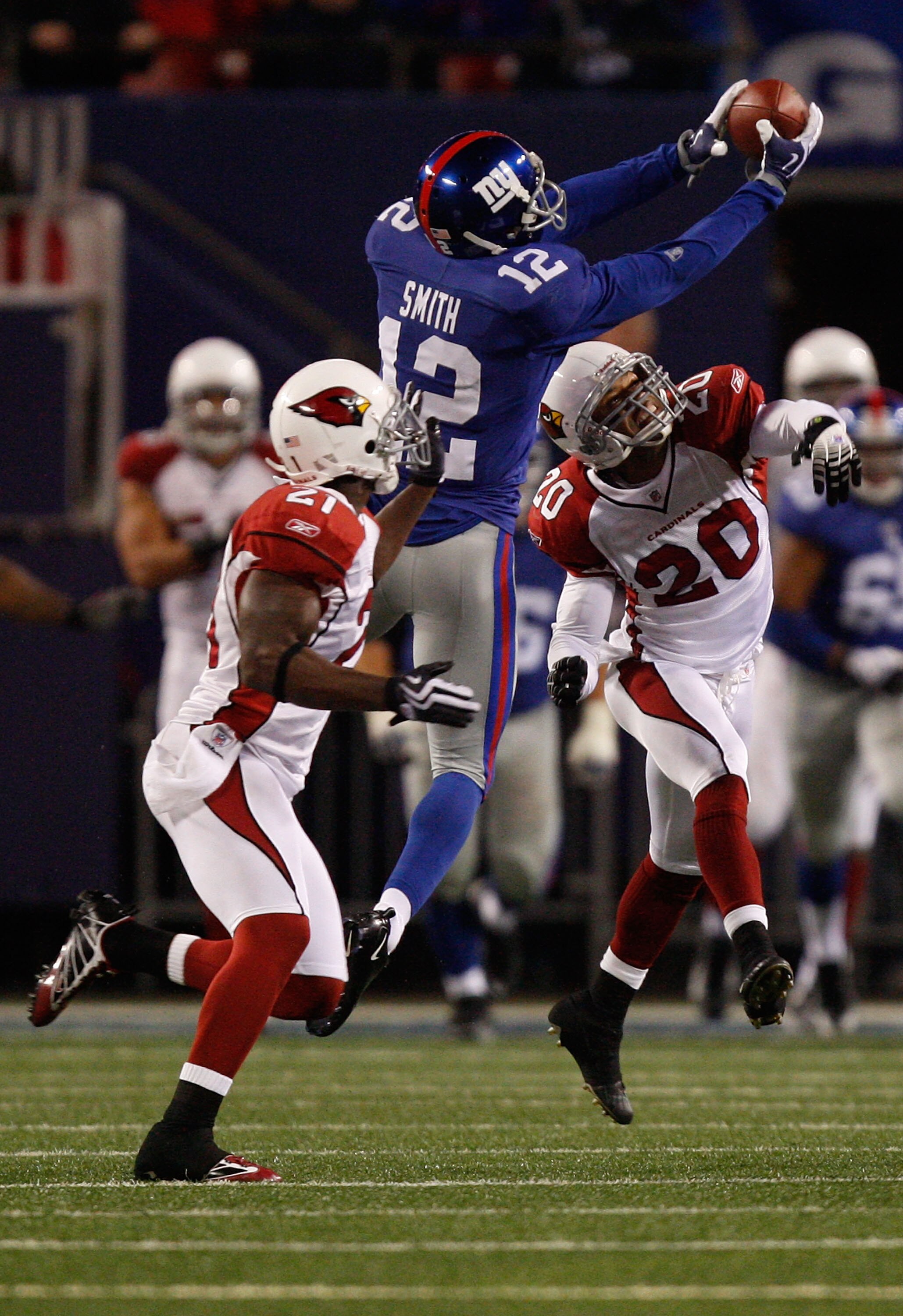 EAST RUTHERFORD, NJ - OCTOBER 25: Steve Smith #12 of the New York Giants makes a catch in front of Antrel Rolle #21 and Ralph Brown #20 of the Arizona Cardinals on October 25, 2009 at Giants Stadium in East Rutherford, New Jersey. (Photo by Jared Wickerha EAST RUTHERFORD, NJ - OCTOBER 25: Steve Smith #12 of the New York Giants makes a catch in front of Antrel Rolle #21 and Ralph Brown #20 of the Arizona Cardinals on October 25, 2009 at Giants Stadium in East Rutherford, New Jersey. (Photo by Jared Wickerha