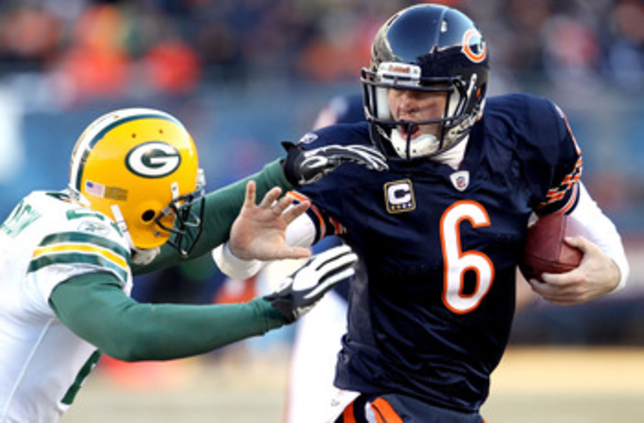 CHICAGO, IL - JANUARY 23:  Quarterback Jay Cutler #6 of the Chicago Bears throws out his right arm to avoid a tackle by Charles Woodson #21 of the Green Bay Packers in the second quarter of the NFC Championship Game at Soldier Field on January 23, 2011 in
