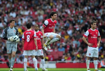 LONDON, ENGLAND - APRIL 17:  Cesc Fabregas of Arsenal jumps while his team wait for medical staff to access the injury to Jamie Carragher of Liverpool during the Barclays Premier League match between Arsenal and Liverpool at the Emirates Stadium on April