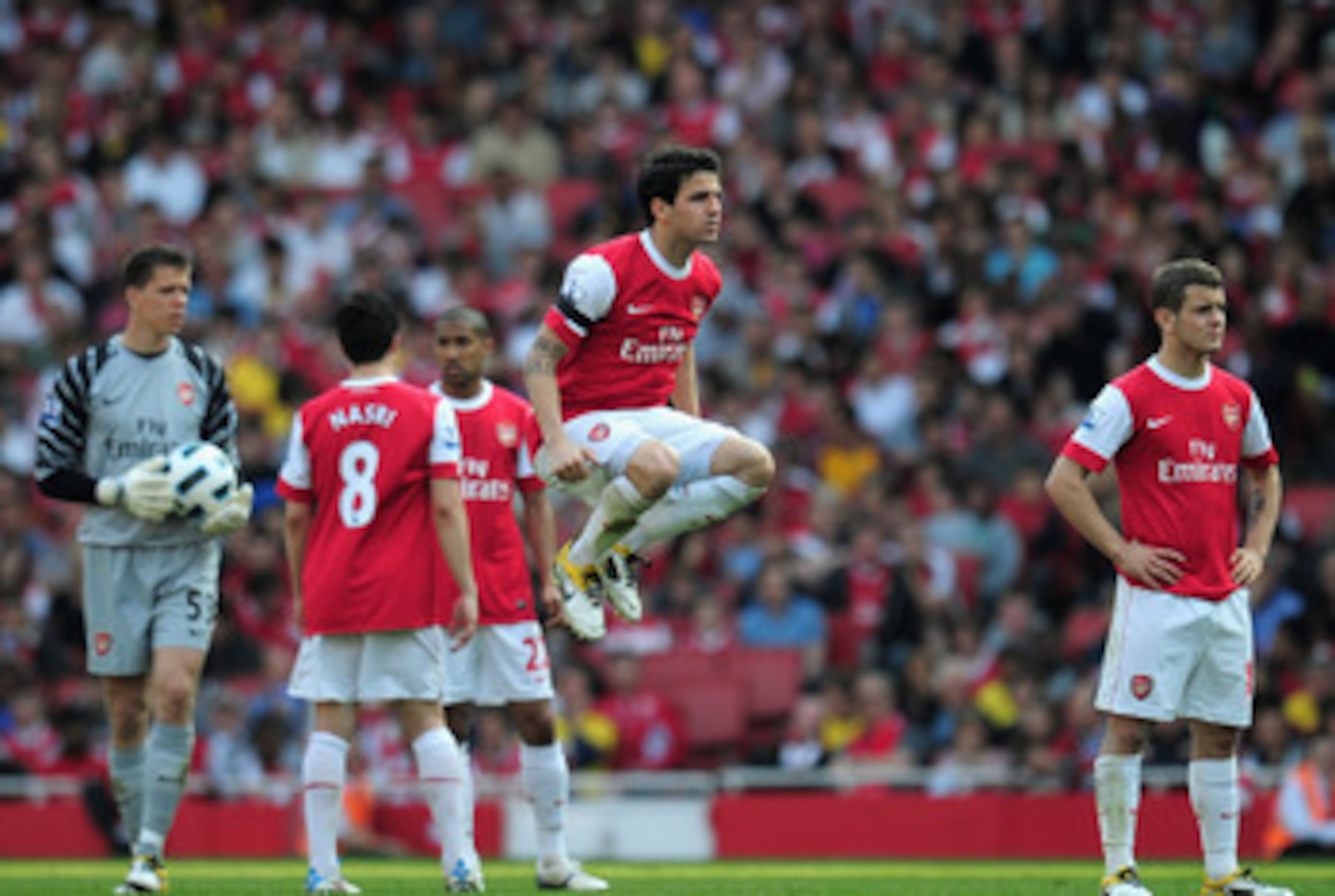 LONDON, ENGLAND - APRIL 17:  Cesc Fabregas of Arsenal jumps while his team wait for medical staff to access the injury to Jamie Carragher of Liverpool during the Barclays Premier League match between Arsenal and Liverpool at the Emirates Stadium on April