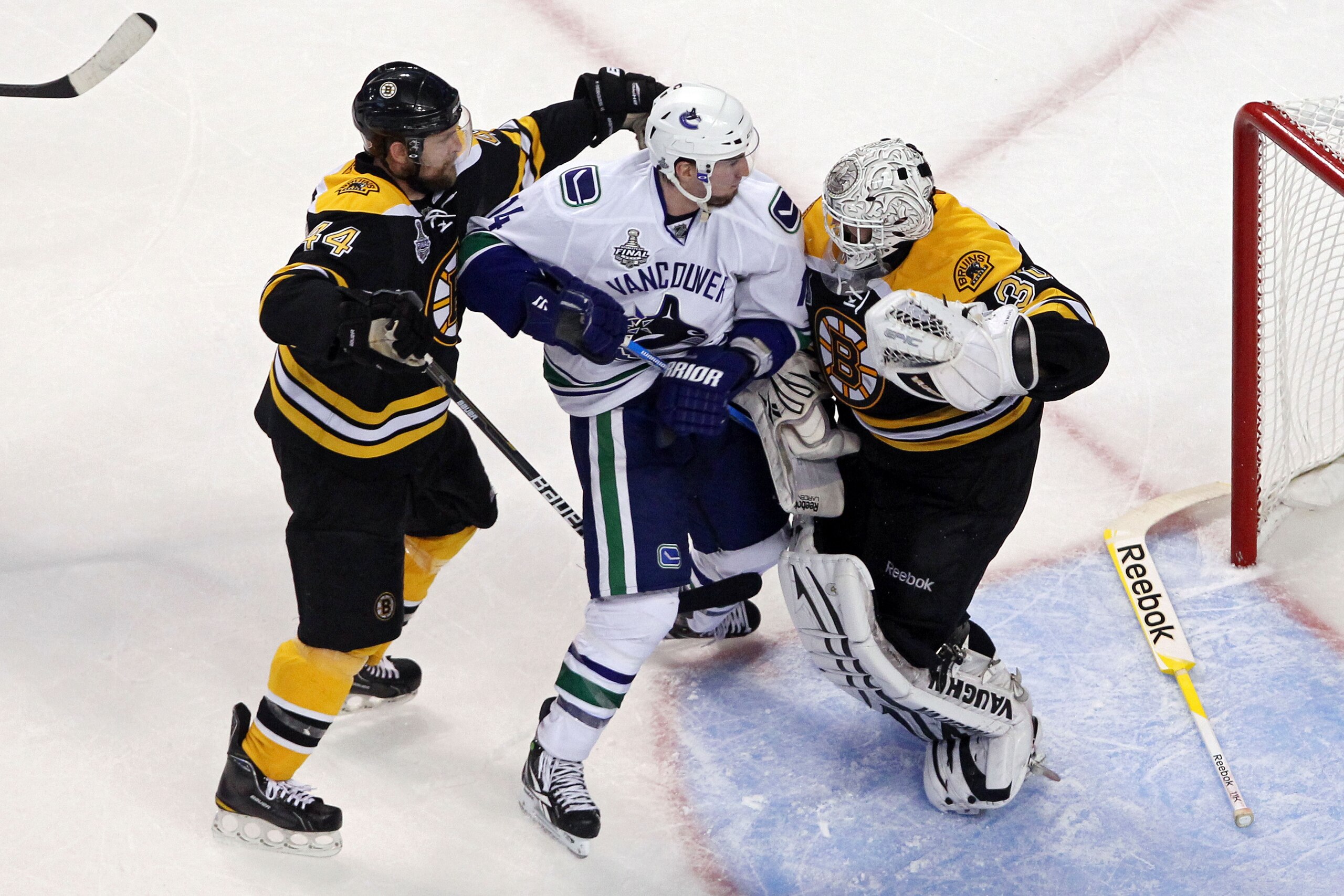 BOSTON, MA - JUNE 08:  Dennis Seidenberg #44 of the Boston Bruins  tackles Alex Burrows #14 of the Vancouver Canucks after an incident with Tim Thomas #30 of the Boston Bruins during Game Four of the 2011 NHL Stanley Cup Final at TD Garden on June 8, 2011