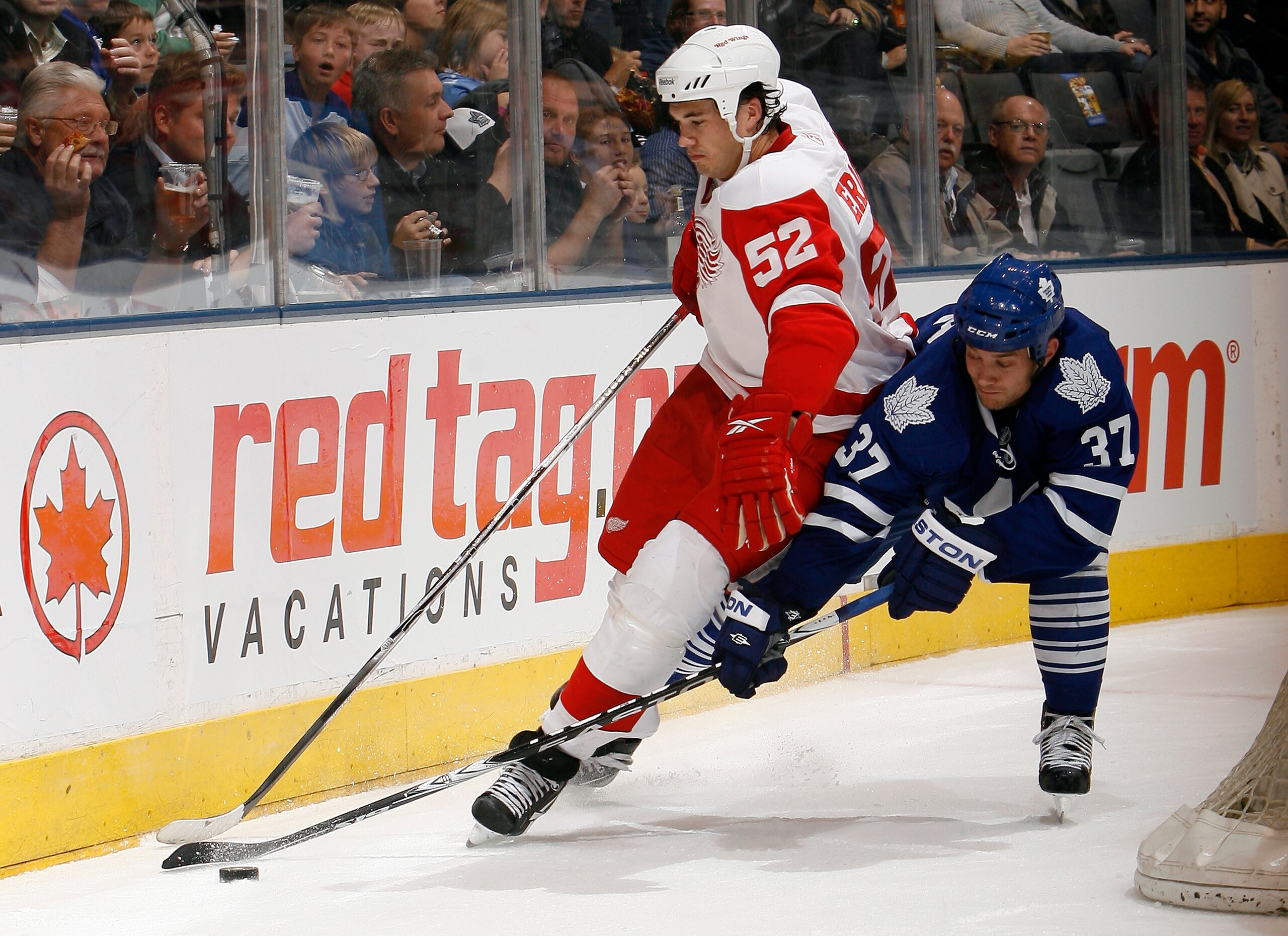 TORONTO - OCTOBER 2: Tim Brent #37 of the Toronto Maple Leafs trips up Jonathan Ericsson #52 of the Detroit Red Wings during a preseason NHL game at the Air Canada Centre October 2, 2010 in Toronto, Ontario, Canada. (Photo by Abelimages/Getty Images)