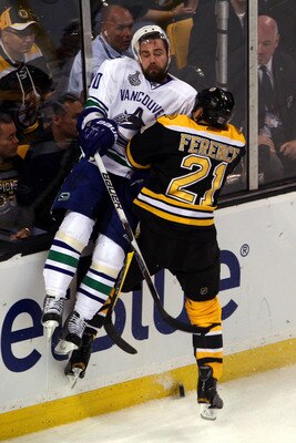 BOSTON, MA - JUNE 06:  Christopher Higgins #20 of the Vancouver Canucks gets checked by Andrew Ference #21 of the Boston Bruins during Game Three of the 2011 NHL Stanley Cup Final at TD Garden on June 6, 2011 in Boston, Massachusetts.  (Photo by Bruce Ben
