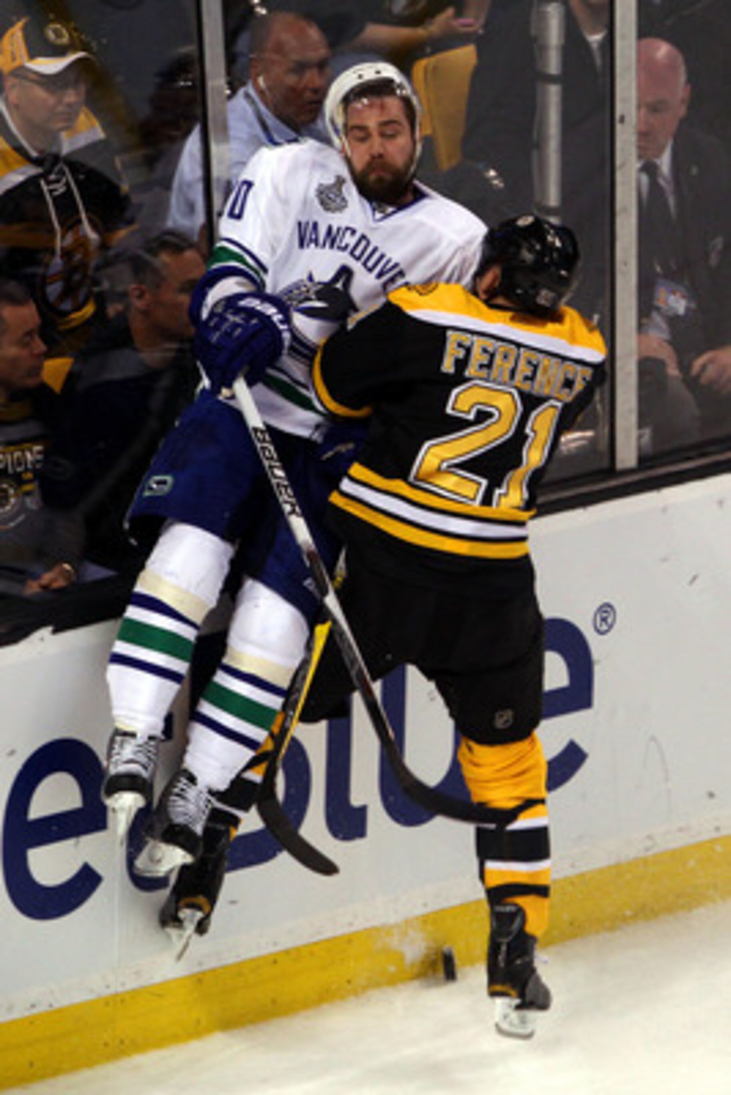BOSTON, MA - JUNE 06:  Christopher Higgins #20 of the Vancouver Canucks gets checked by Andrew Ference #21 of the Boston Bruins during Game Three of the 2011 NHL Stanley Cup Final at TD Garden on June 6, 2011 in Boston, Massachusetts.  (Photo by Bruce Ben
