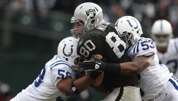 OAKLAND, CA - DECEMBER 26: Kavell Conner #53 and Tyjuan Hagler #56 of the Indianapolis Colts tackle Zach Miller #80 of the Oakland Raiders during an NFL game at Oakland-Alameda County Coliseum on December  26, 2010 in Oakland, California.  (Photo by Jed J