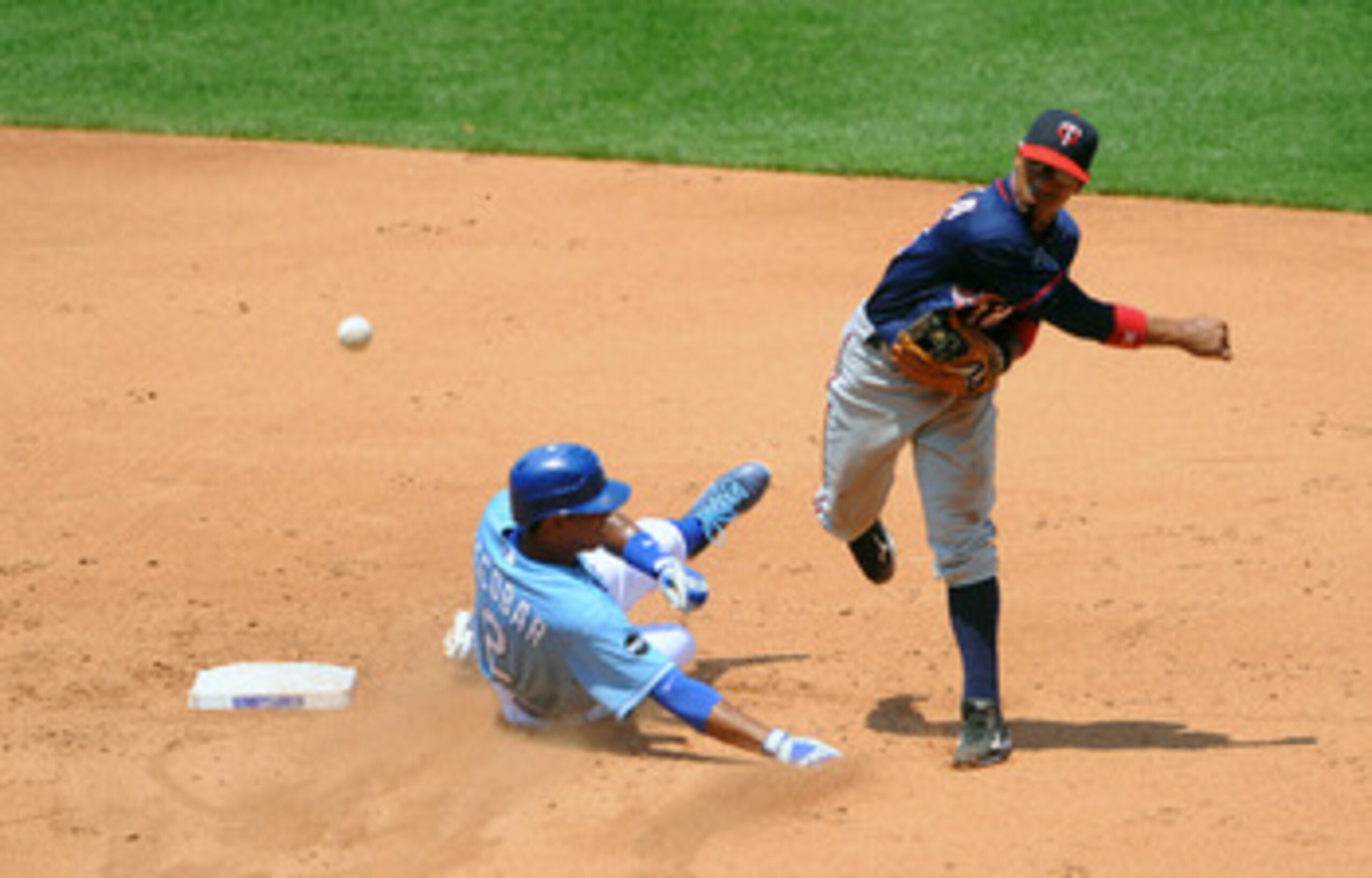 KANSAS CITY, MO - JUNE 5: Alexi Casilla #12 of the Minnesota Twins throws to first base to complete a double play as Alcides Escobar #2 of the Kansas City Royals slides in at Kauffman Stadium on June 5, 2011 in Kansas City, Missouri. (Photo by G. Newman KANSAS CITY, MO - JUNE 5: Alexi Casilla #12 of the Minnesota Twins throws to first base to complete a double play as Alcides Escobar #2 of the Kansas City Royals slides in at Kauffman Stadium on June 5, 2011 in Kansas City, Missouri. (Photo by G. Newman