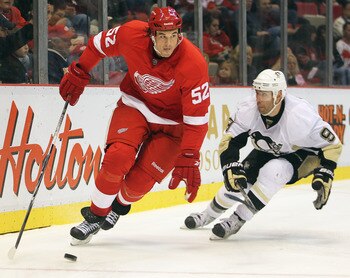 DETROIT, MI - OCTOBER 03:  Jonathan Ericsson #52 of the Detroit Red Wings skates away from a check by Pascal Dupuis #9 of the Pittsburgh Penguins in a preseason game on October 3, 2010 at the Joe Louis Arena in Detroit, Michigan. The Penguins defeated the