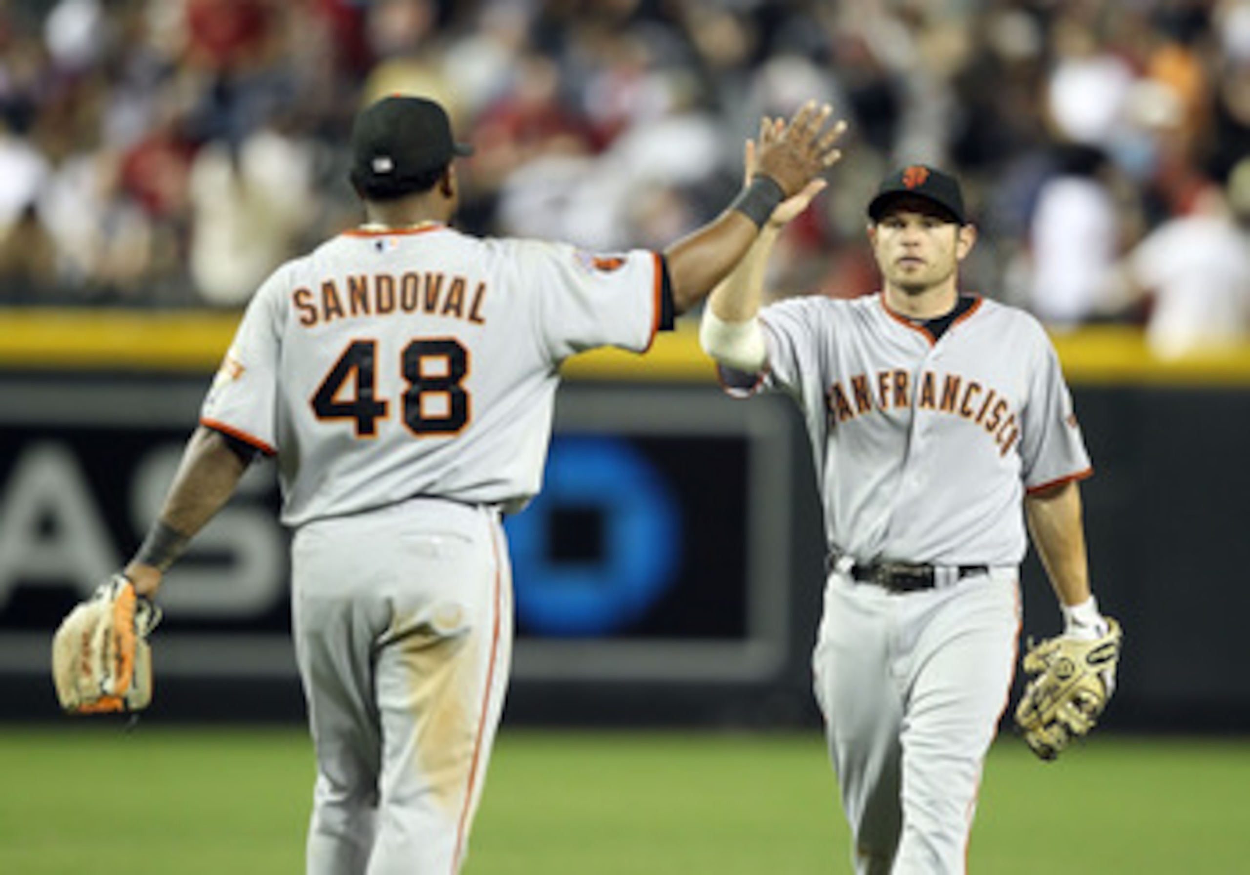 PHOENIX, AZ - APRIL 16:  Freddy Sanchez #21 of the San Francisco Giants high fives teammate Pablo Sandoval #48 after defeating the Arizona Diamondbacks during the Major League Baseball game at Chase Field on April 16, 2011 in Phoenix, Arizona. The Giants 