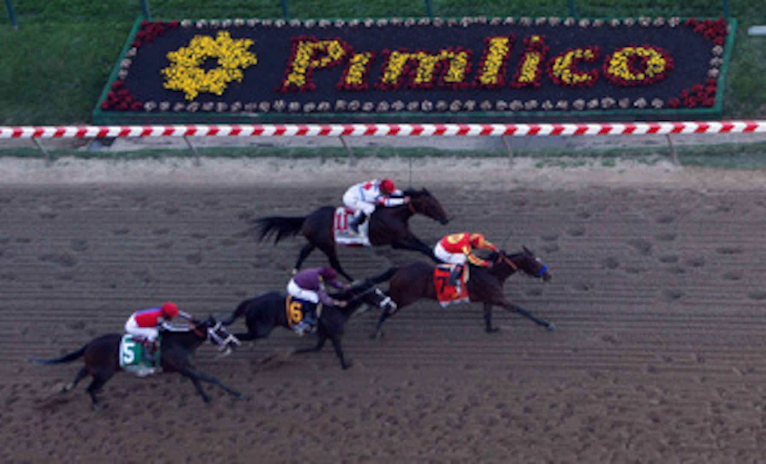 BALTIMORE - MAY 15:  Lookin At Lucky (center), ridden by Martin Garcia #7, holds off First Dude, ridden by Ramon Dominguez #11, Jackson Bend , ridden by Mike Smith #6, and Yawanna Twist, ridden by Edgar Prado #5, down the homestrech to win the 135th runni