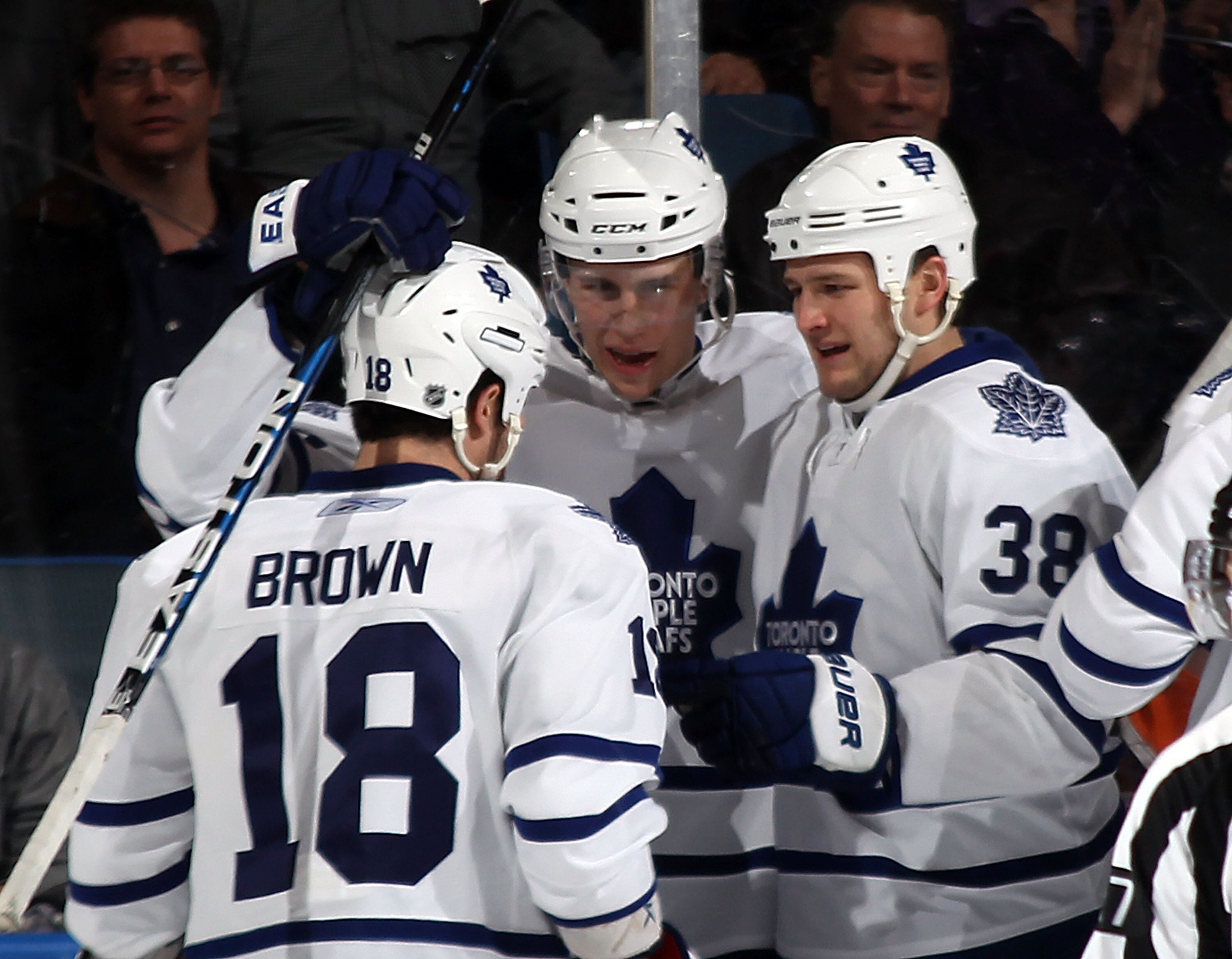 UNIONDALE, NY - MARCH 08: Mike Brown #18 (L) and Jay Rosehill #38 (R) of the Toronto Maple Leafs congratulate Keith Aulie #59 (C) on his first NHL goal 2:49 of the second period against the New York Islanders at the Nassau Coliseum on March 8, 2011 in Uni