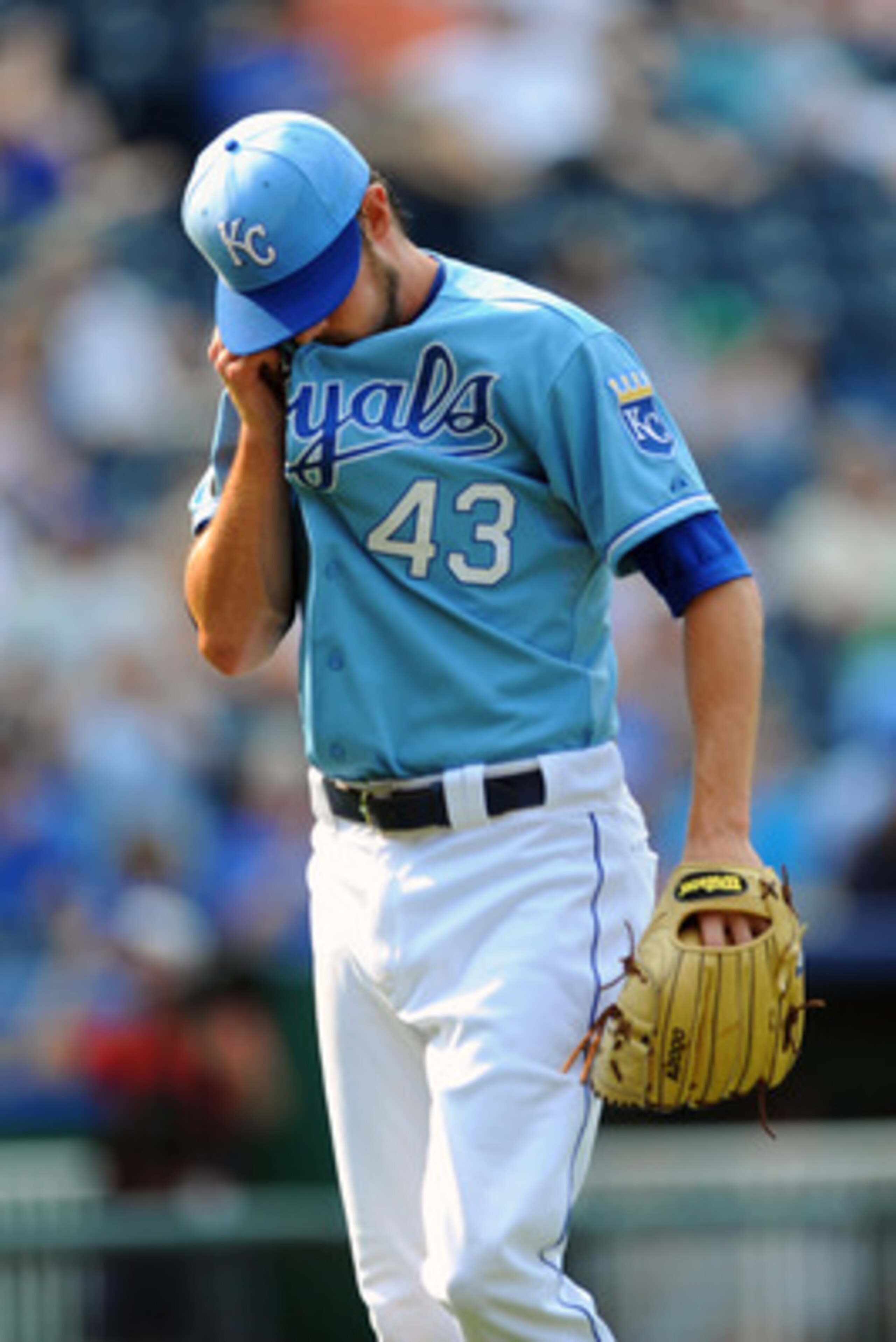KANSAS CITY, MO - JUNE 9:  Aaron Crow #43 of the Kansas City Royals wipes his face as he walks back to the dugout following the eight inning against the Toronto Blue Jays at Kauffman Stadium on June 9, 2011 in Kansas City, Missouri. The Royals defeated th