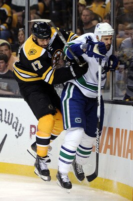 BOSTON, MA - JUNE 08:  Milan Lucic #17 of the Boston Bruins checks Andrew Alberts #41 of the Vancouver Canucks during Game Four of the 2011 NHL Stanley Cup Final at TD Garden on June 8, 2011 in Boston, Massachusetts.  (Photo by Harry How/Getty Images)