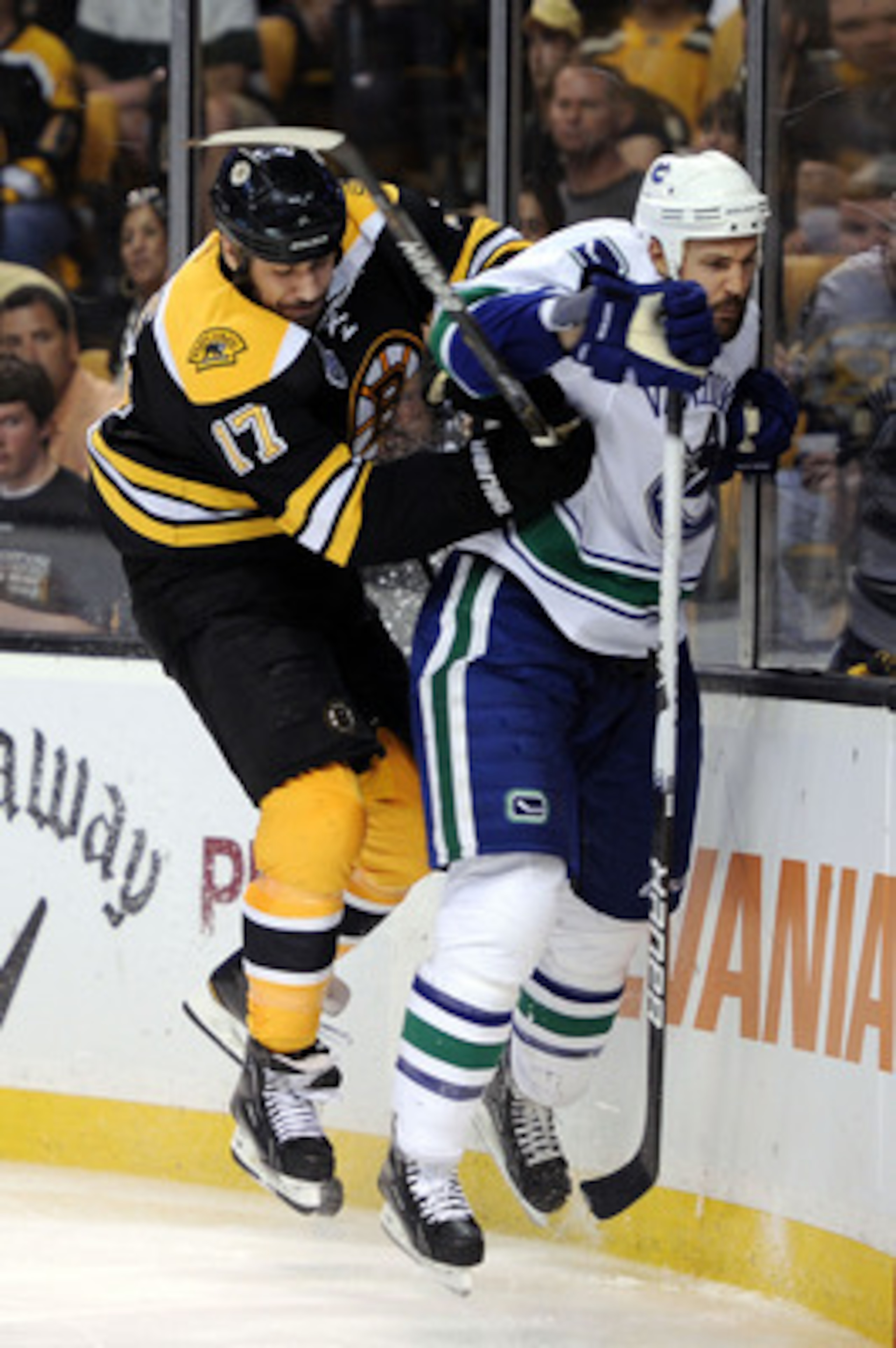 BOSTON, MA - JUNE 08:  Milan Lucic #17 of the Boston Bruins checks Andrew Alberts #41 of the Vancouver Canucks during Game Four of the 2011 NHL Stanley Cup Final at TD Garden on June 8, 2011 in Boston, Massachusetts.  (Photo by Harry How/Getty Images)