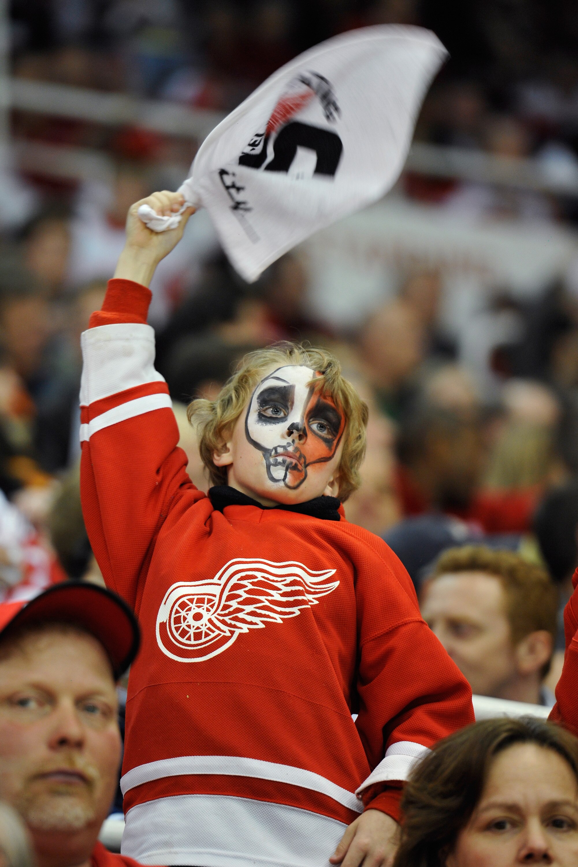 DETROIT - MAY 4:  A young Detroit Red Wings fan cheers his team on in the second period against the San Jose Sharks in Game Three of the Western Conference Semifinals during the 2011 NHL Stanley Cup Playoffs on May 4, 2011 at Joe Louis Arena in Detroit, M