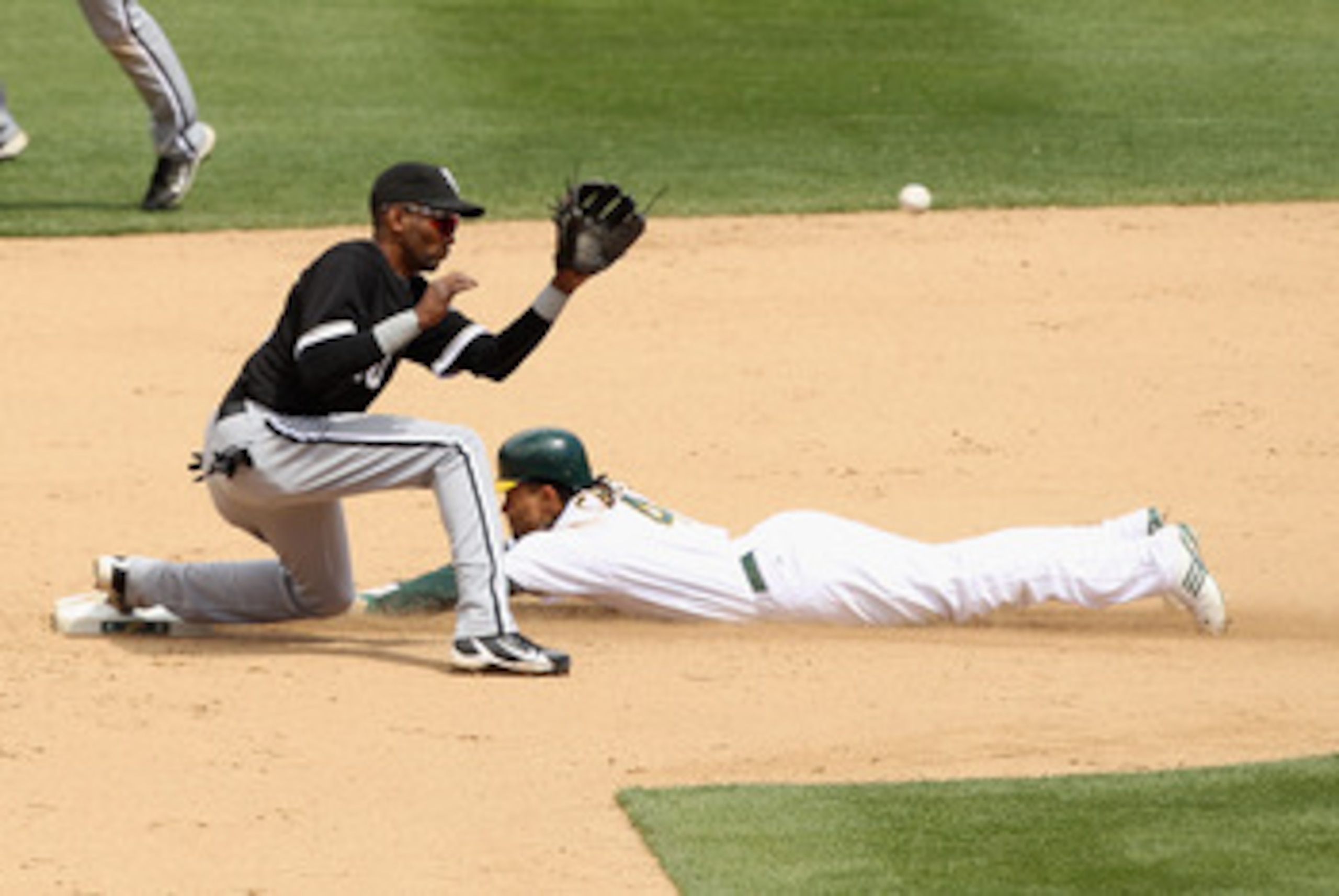 OAKLAND, CA - MAY 15:  Coco Crisp #4 of the Oakland Athletics slides safely past Alexei Ramirez #10 of the Chicago White Sox to steal second base at Oakland-Alameda County Coliseum on May 15, 2011 in Oakland, California.  (Photo by Ezra Shaw/Getty Images)