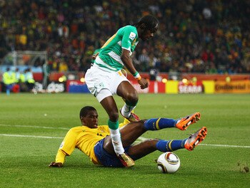 JOHANNESBURG, SOUTH AFRICA - JUNE 20: Juan of Brazil tackles Gervinho of Ivory Coast during the 2010 FIFA World Cup South Africa Group G match between Brazil and Ivory Coast at Soccer City Stadium on June 20, 2010 in Johannesburg, South Africa.  (Photo by