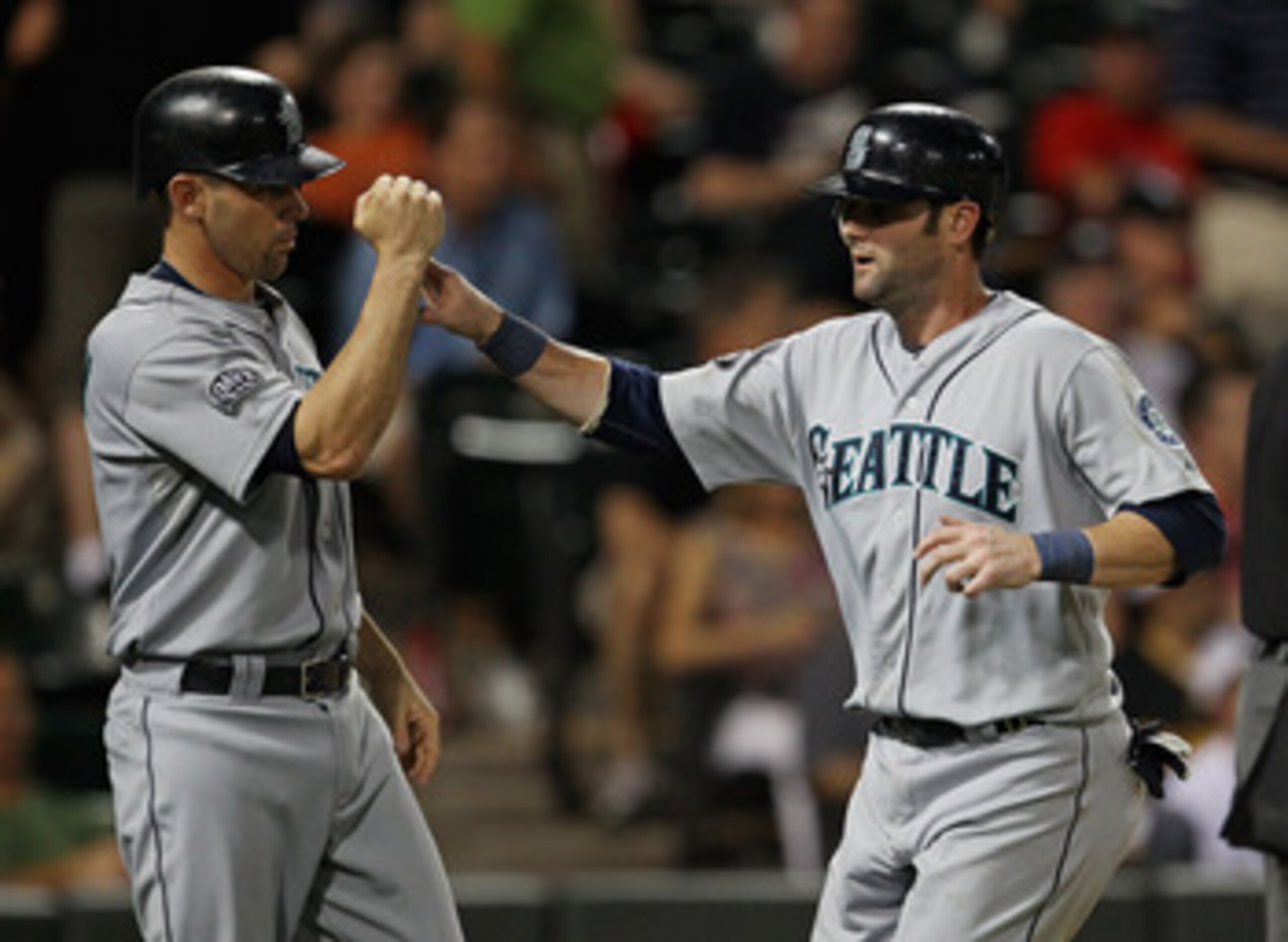CHICAGO, IL - JUNE 08: Jack Wilson #2 of the Seattle Mariners (L) congratulates teammate Adam Kennedy #4 after both scored runs in the 10th inning against the Chicago White Sox at U.S. Cellular Field on June 8, 2011 in Chicago, Illinois. The Mariners defe