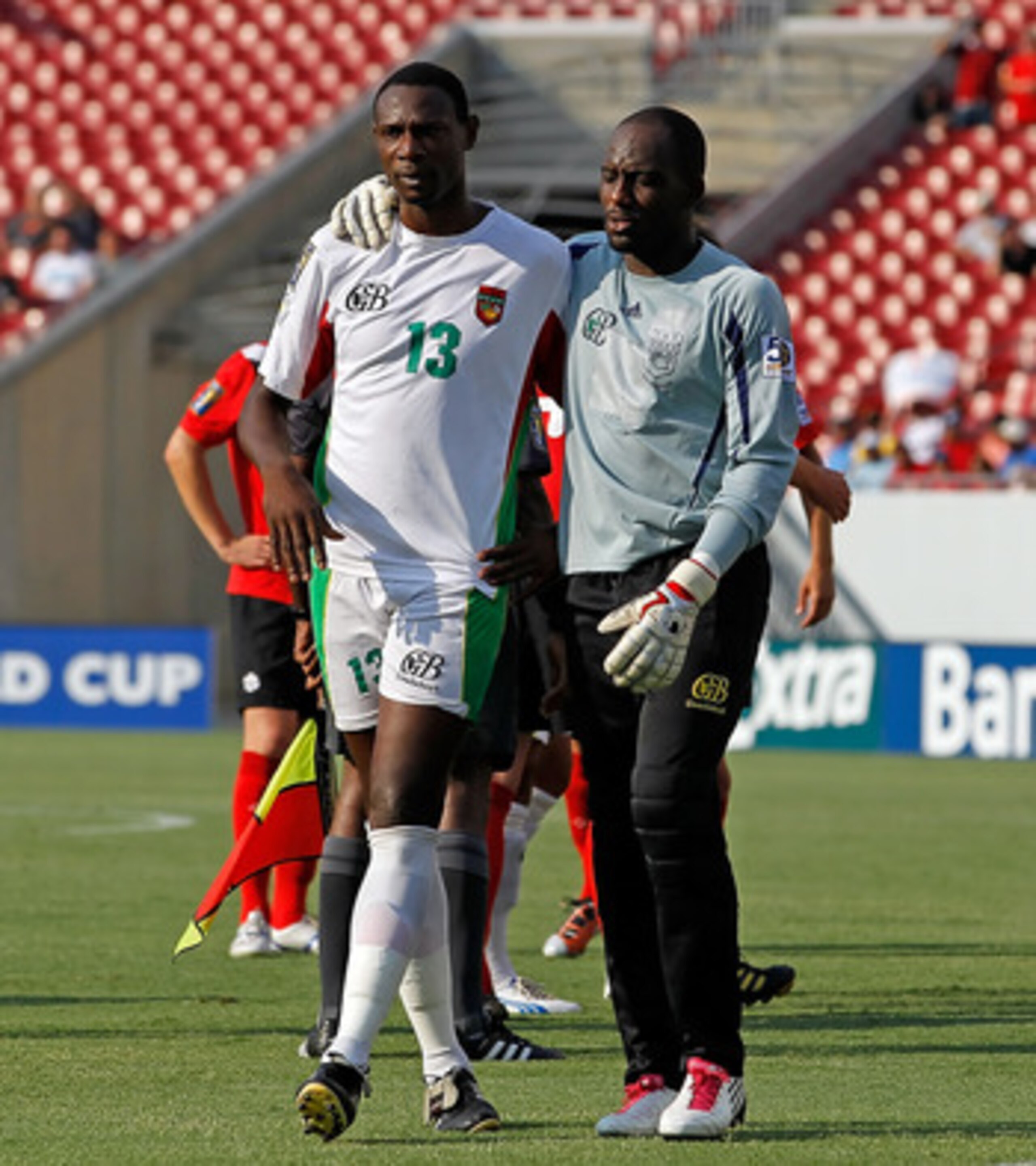 TAMPA, FL - JUNE 11:  Jean-Luc Lambourde #13 of Team Guadeloupe is comforted by Franck Grandel #1 after receiving a red card against Team Canada during the CONCACAF Gold Cup Match at Raymond James Stadium on June 11, 2011 in Tampa, Florida.  (Photo by J. 