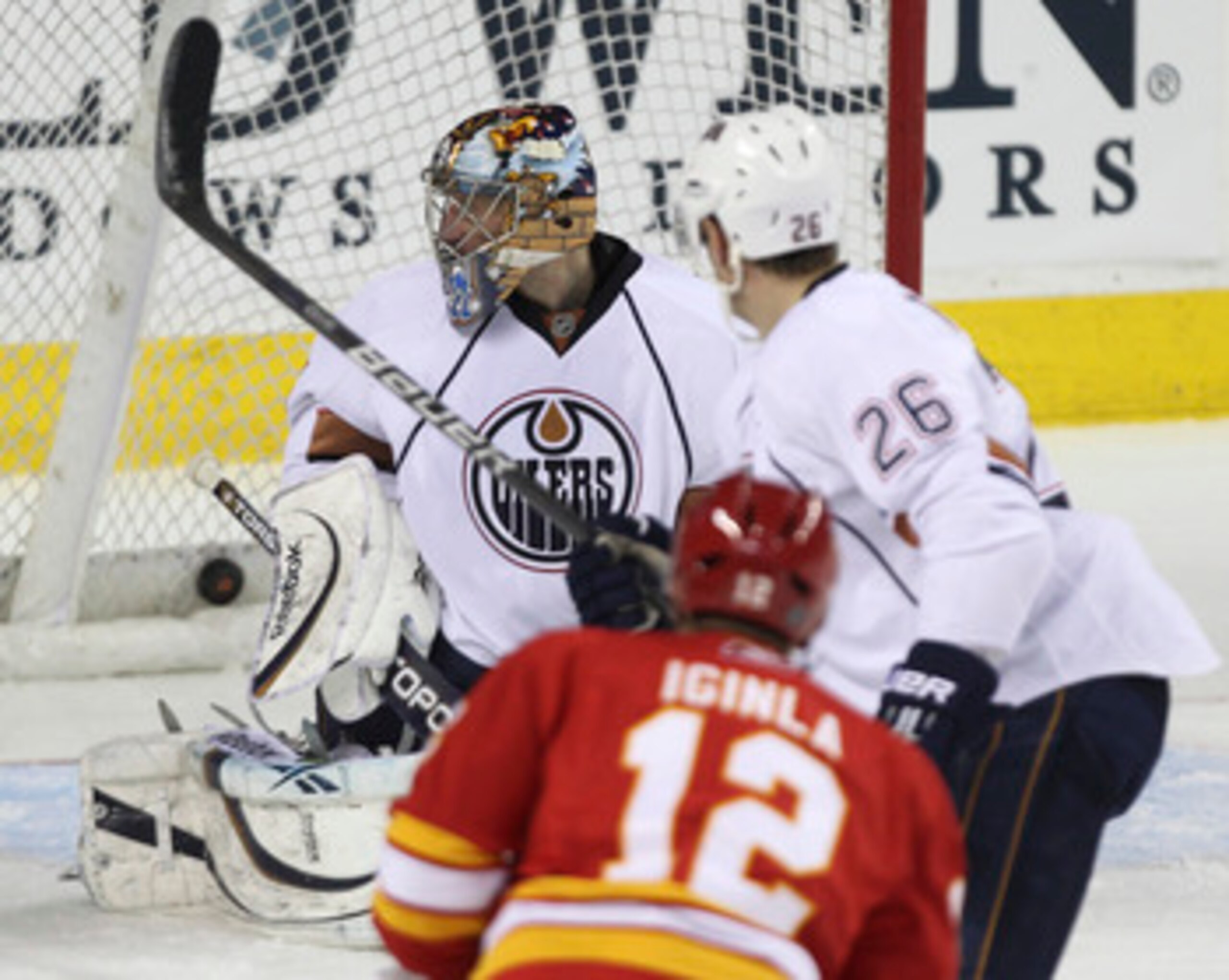 CALGARY, CANADA - APRIL 6: Jarome Iginla #12 of the Calgary Flames score his 40th goal of the season against Nikolai Khabibulin #35 of the Edmonton Oilers as Oilers Kurtis Foster #26 looks on in second period NHL action on April 6, 2011 at the Scotiabank CALGARY, CANADA - APRIL 6: Jarome Iginla #12 of the Calgary Flames score his 40th goal of the season against Nikolai Khabibulin #35 of the Edmonton Oilers as Oilers Kurtis Foster #26 looks on in second period NHL action on April 6, 2011 at the Scotiabank