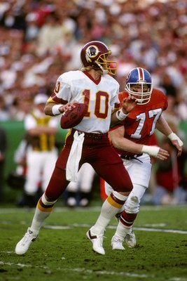 SAN DIEGO - JANUARY 31:  Quarterback Jay Schroeder #10 of the Washington Redskins drops back to pass under pressure from defensive end Karl Mecklenburg #77 of the Denver Broncos during Super Bowl XXII at Jack Murphy Stadium on January 31, 1988 in San Dieg