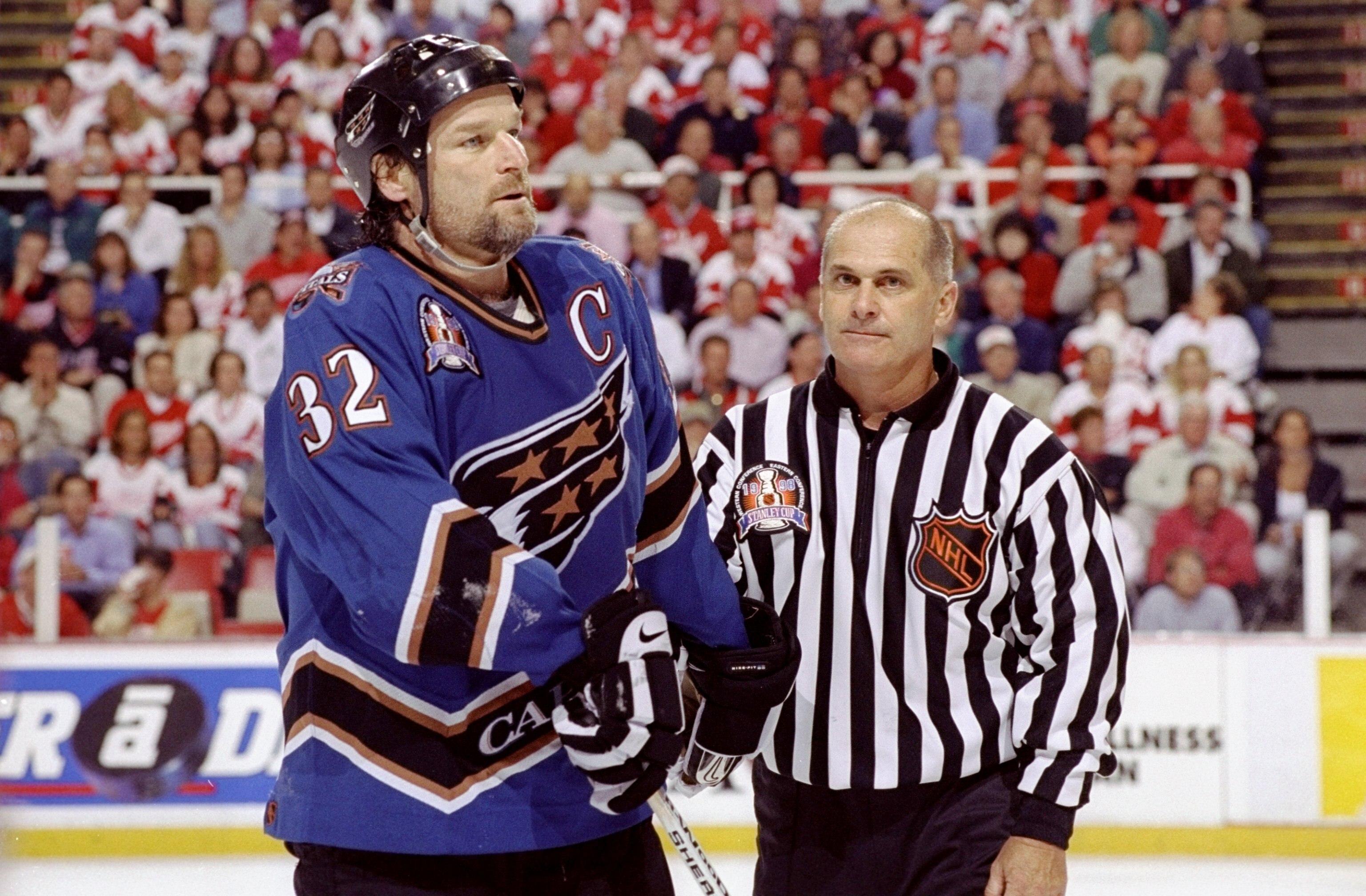 9 Jun 1998:  Dale Hunter #32 of the Washington Capitals iis escorted off by a referee during the NHL Stanley Cup Finals game against the Detroit Red Wings at the Joe Louis Arena in Detroit, Michigan. The Red Wings defeated the Capitals 2-1. Mandatory Cred