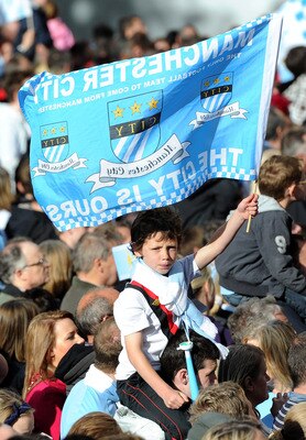 MANCHESTER, ENGLAND - MAY 23:  A young Manchester City fan waves a flag during the Manchester City FA Cup Winners Parade at Manchester Town Hall on May 23, 2011 in Manchester, United Kingdom.  (Photo by Chris Brunskill/Getty Images)
