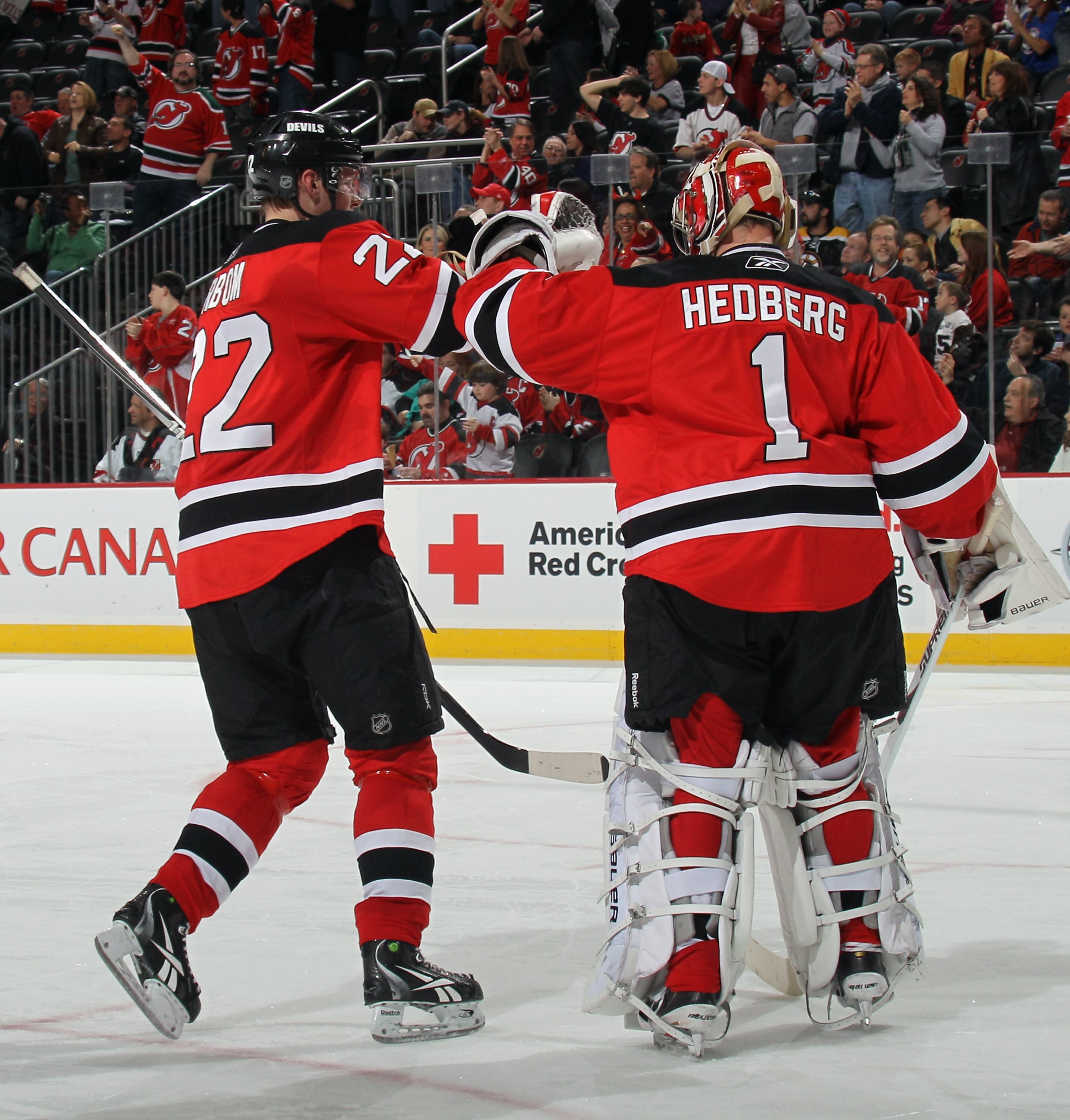 NEWARK, NJ - APRIL 10:  Alexander Urbom #22 of the New Jersey Devils celebrates his first NHL goal at 9:10 of the third period along with Johan Hedberg #1 in their game against the Boston Bruins at the Prudential Center on April 10, 2011 in Newark, New Je