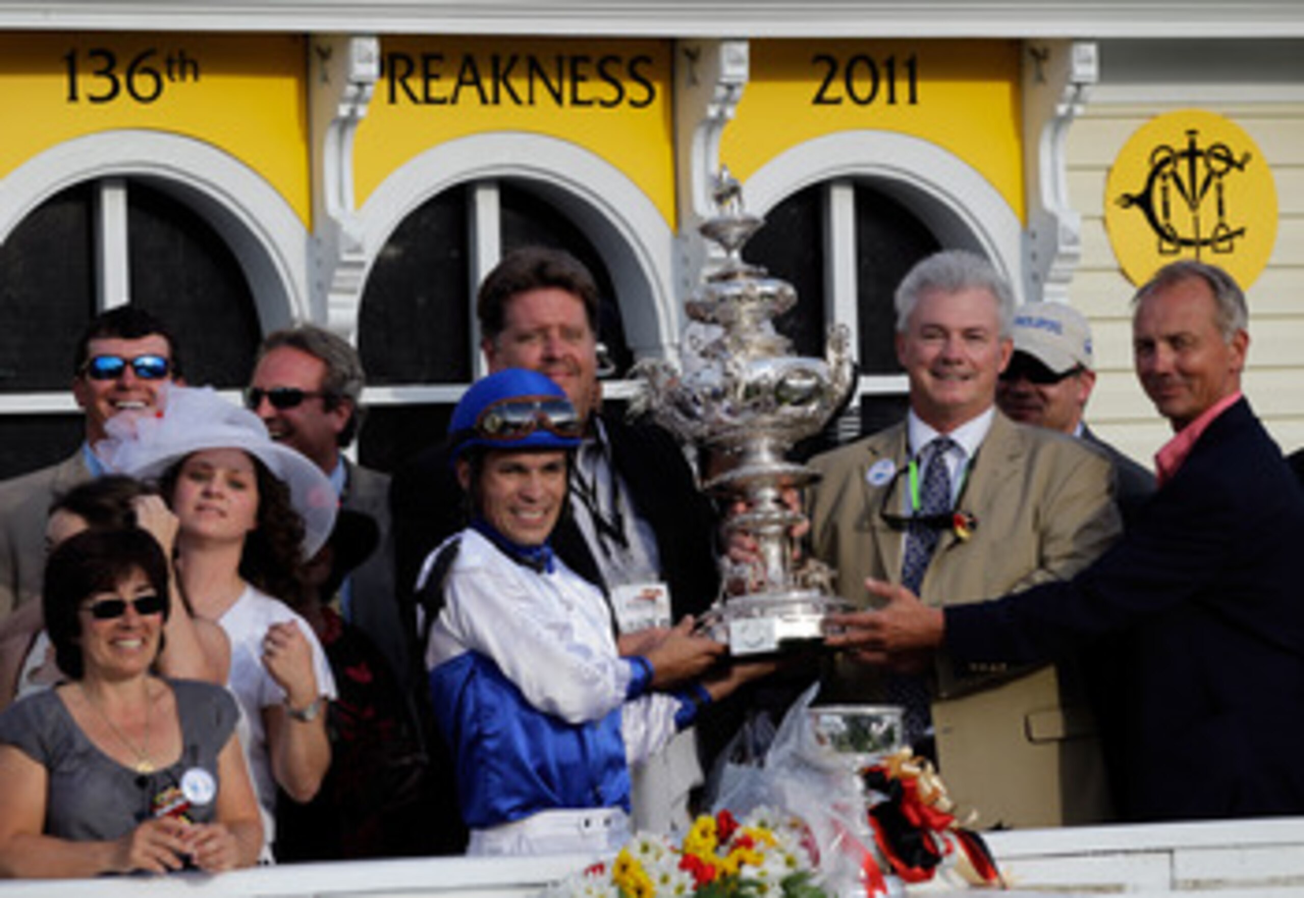 BALTIMORE, MD - MAY 21:  Jockey Jesus Castanon (L) along with trainer Mike Romans, and co-owners Mike Lauffer, and Bill Cubbedge (R) celebrate with the trophy in the winners circle after their horse Shackleford #5 won the 136th running of the Preakness St