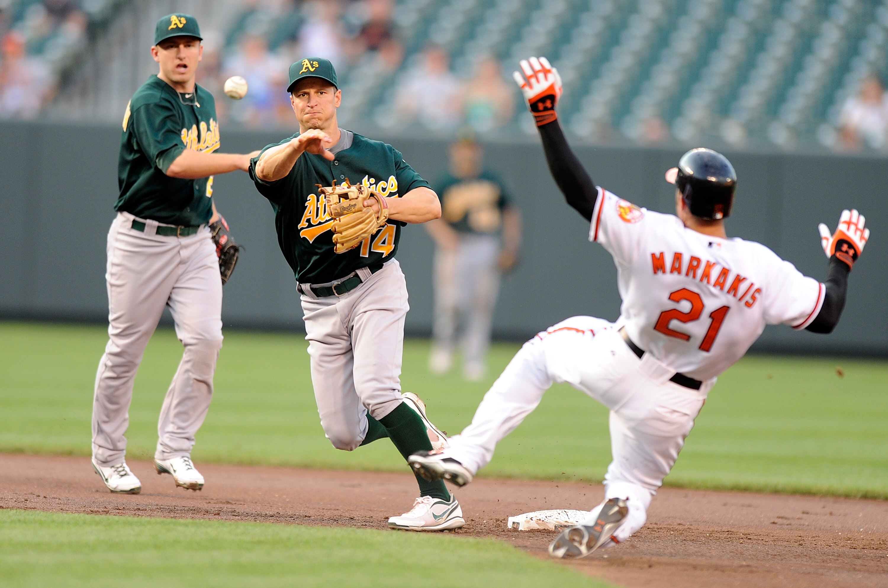 BALTIMORE, MD - JUNE 06:  Mark Ellis #14 of the Oakland Athletics forces out Nick Markakis #21 of the Baltimore Orioles to start a double play in the first inning at Oriole Park at Camden Yards on June 6, 2011 in Baltimore, Maryland.  (Photo by Greg Fiume