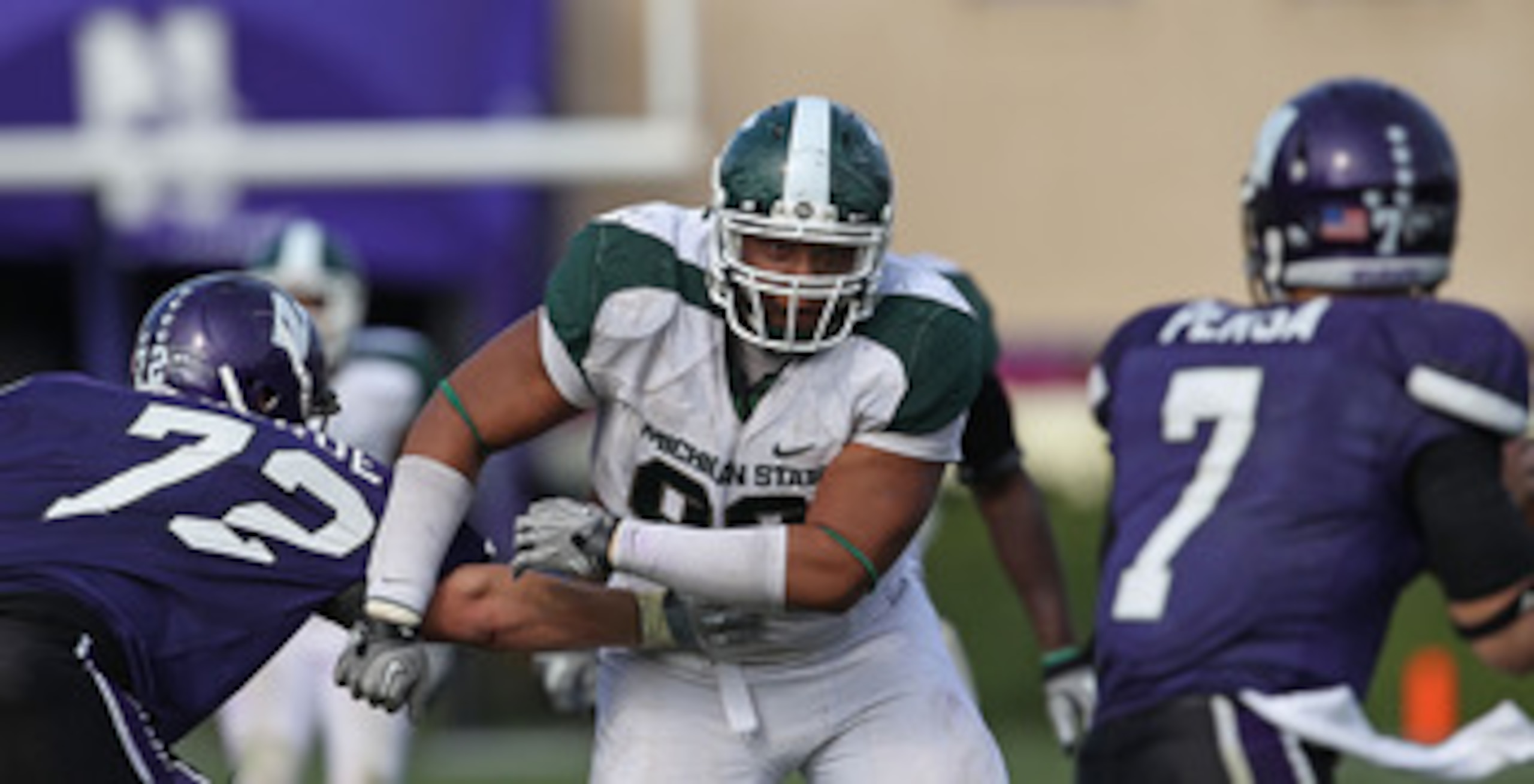 EVANSTON, IL - OCTOBER 23: Jerel Worthy #99 of the Michigan State Spartans moves past a block attempt by Brian Mulroe #72 of the Northwestern Wildcats with his sights set on Dan Persa #7 at Ryan Field on October 23, 2010 in Evanston, Illinois. Michigan St