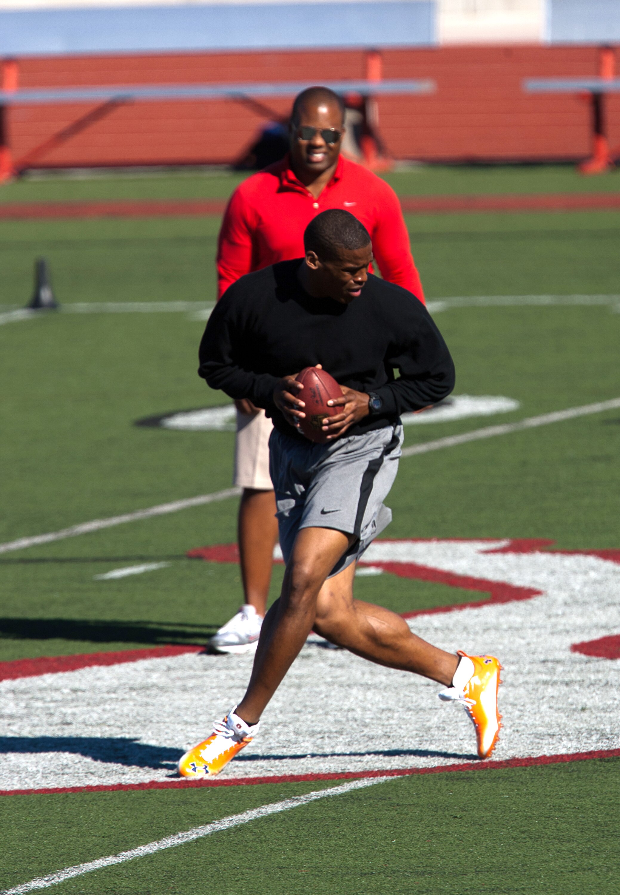 SAN DIEGO, CA - FEBRUARY 10:  2010 Heisman Trophy winning quarterback Cam Newton of the Auburn Tigers goes through his workout routine for the media under the watchful eye of trainer George Whitfield  at Cathedral High School's sports stadium on February