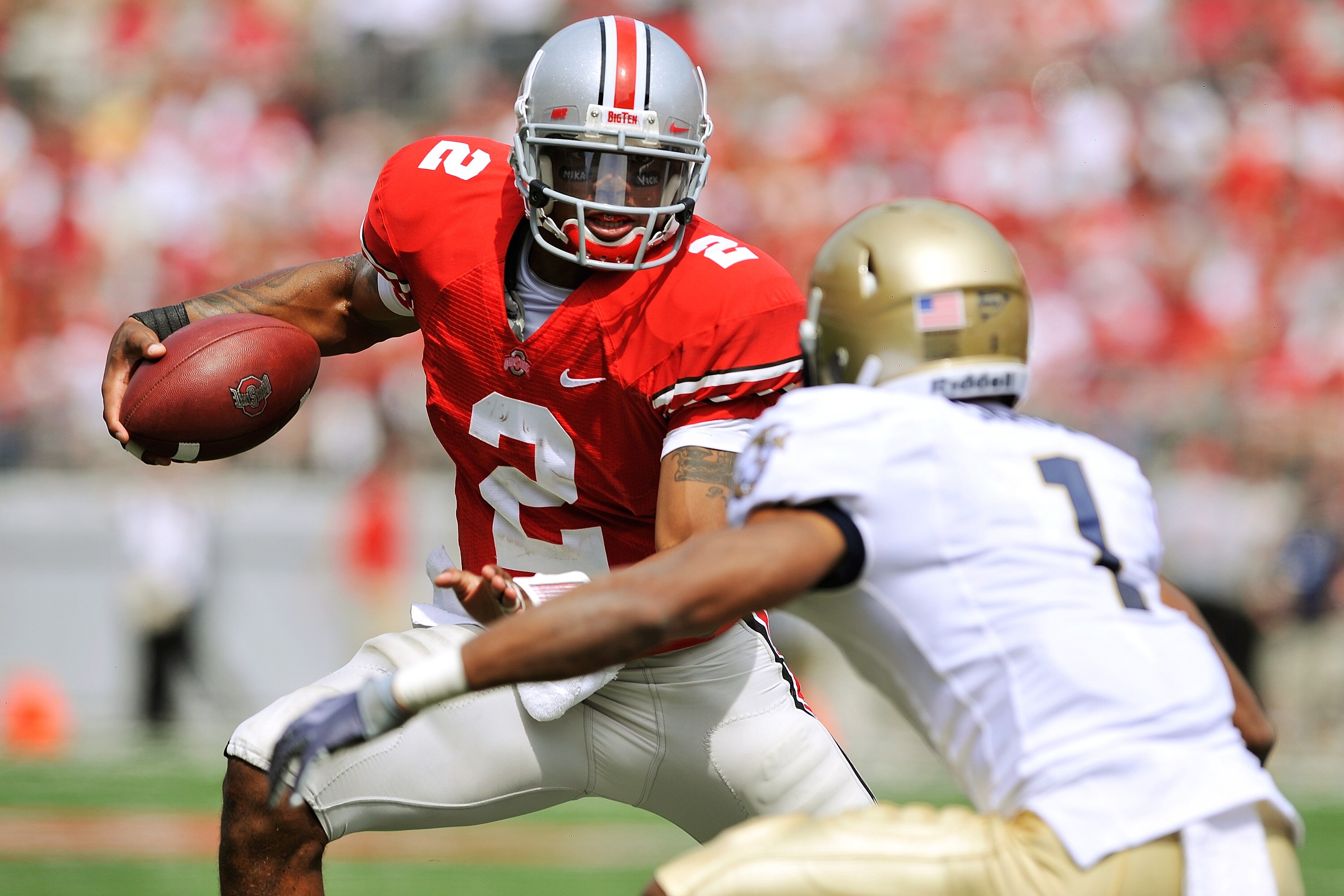 COLUMBUS, OH - SEPTEMBER 05:  Quarterback Terrelle Pryor #2 of the Ohio State Buckeyes tries to elude the tackle of Blake Carter #1 of the Navy Midshipmen at Ohio Stadium on September 5, 2009 in Columbus, Ohio.  Pryor ran for one touchdown and threw for o