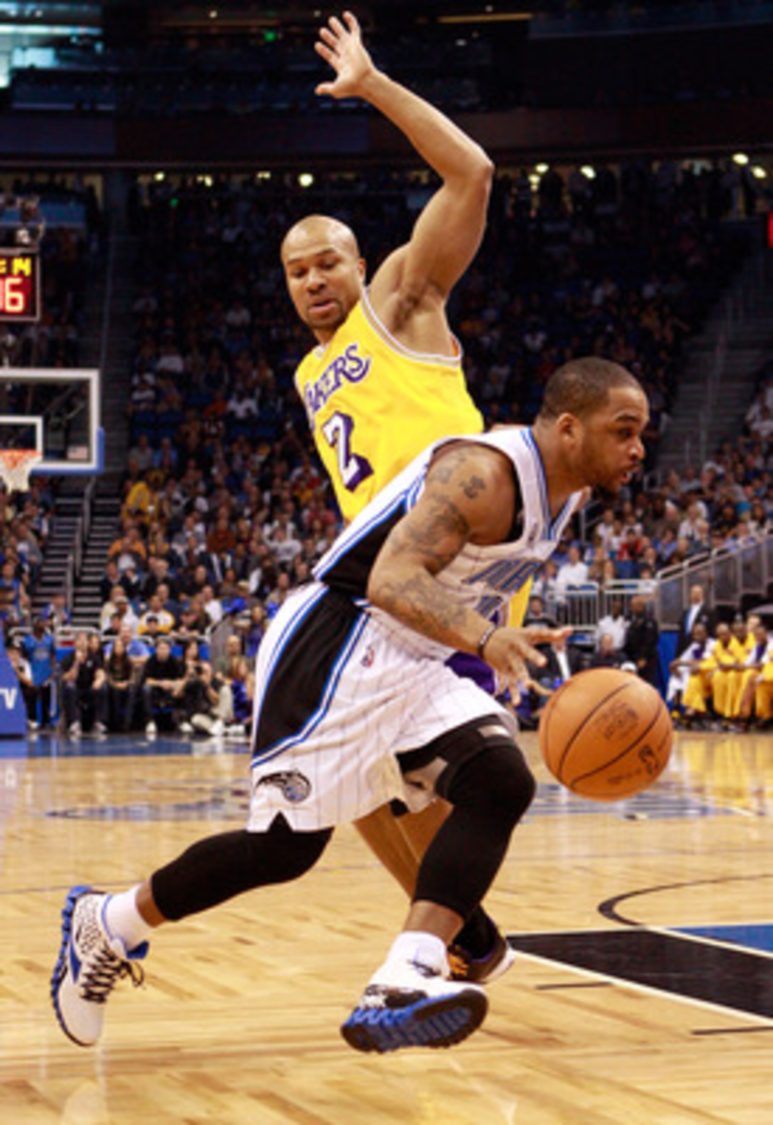 ORLANDO, FL - FEBRUARY 13:  Jameer Nelson #14 of the Orlando Magic drives past Derek Fisher #2 of the Los Angeles Lakers during the game at Amway Arena on February 13, 2011 in Orlando, Florida.  NOTE TO USER: User expressly acknowledges and agrees that, b