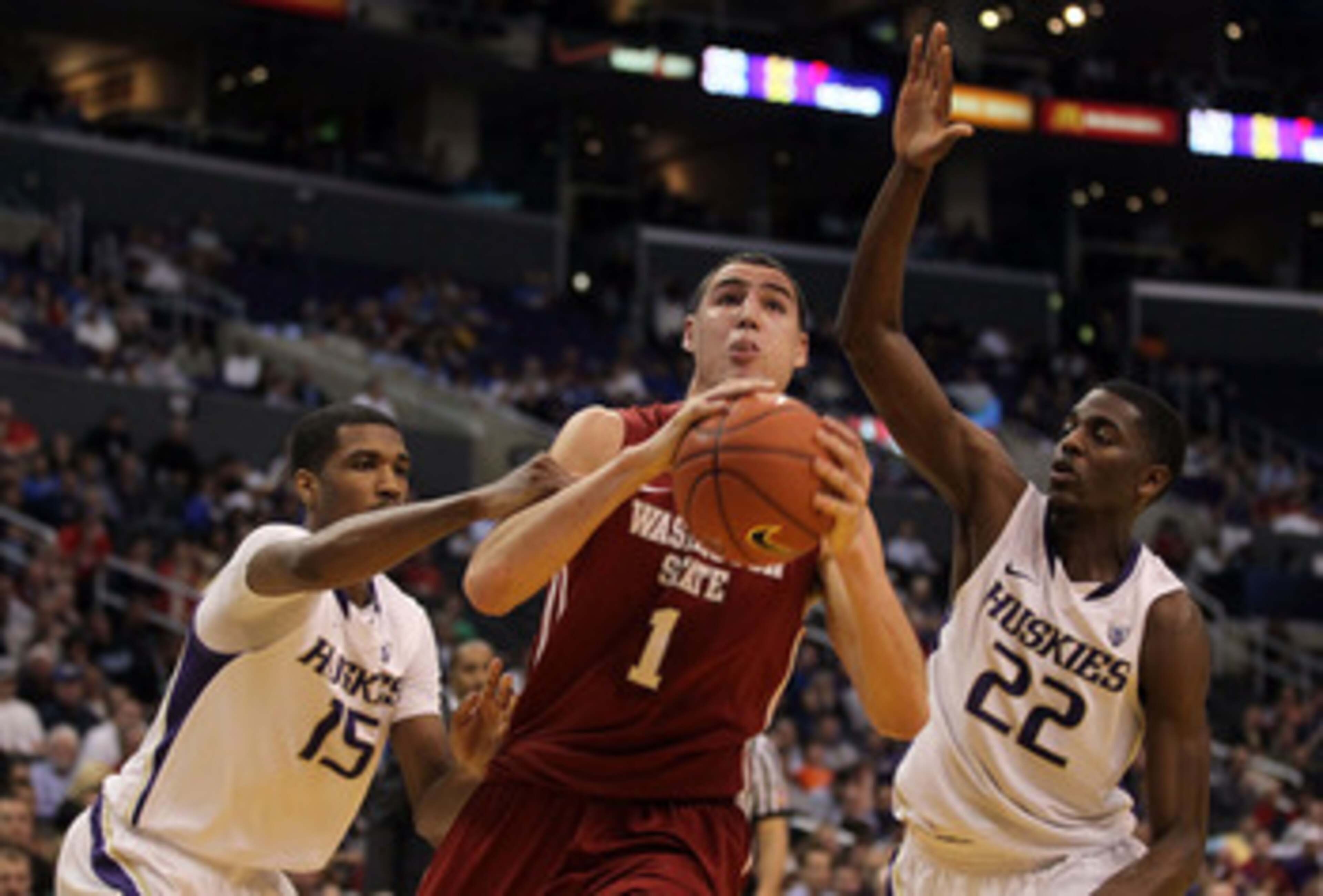 LOS ANGELES, CA - MARCH 10:  Klay Thompson #1 of the Washington State Cougars drives between Scott Suggs #15 and Justin Holiday #22 of the Washington Huskies in the first half in the quarterfinals of the 2011 Pacific Life Pac-10 Men's Basketball Tournamen