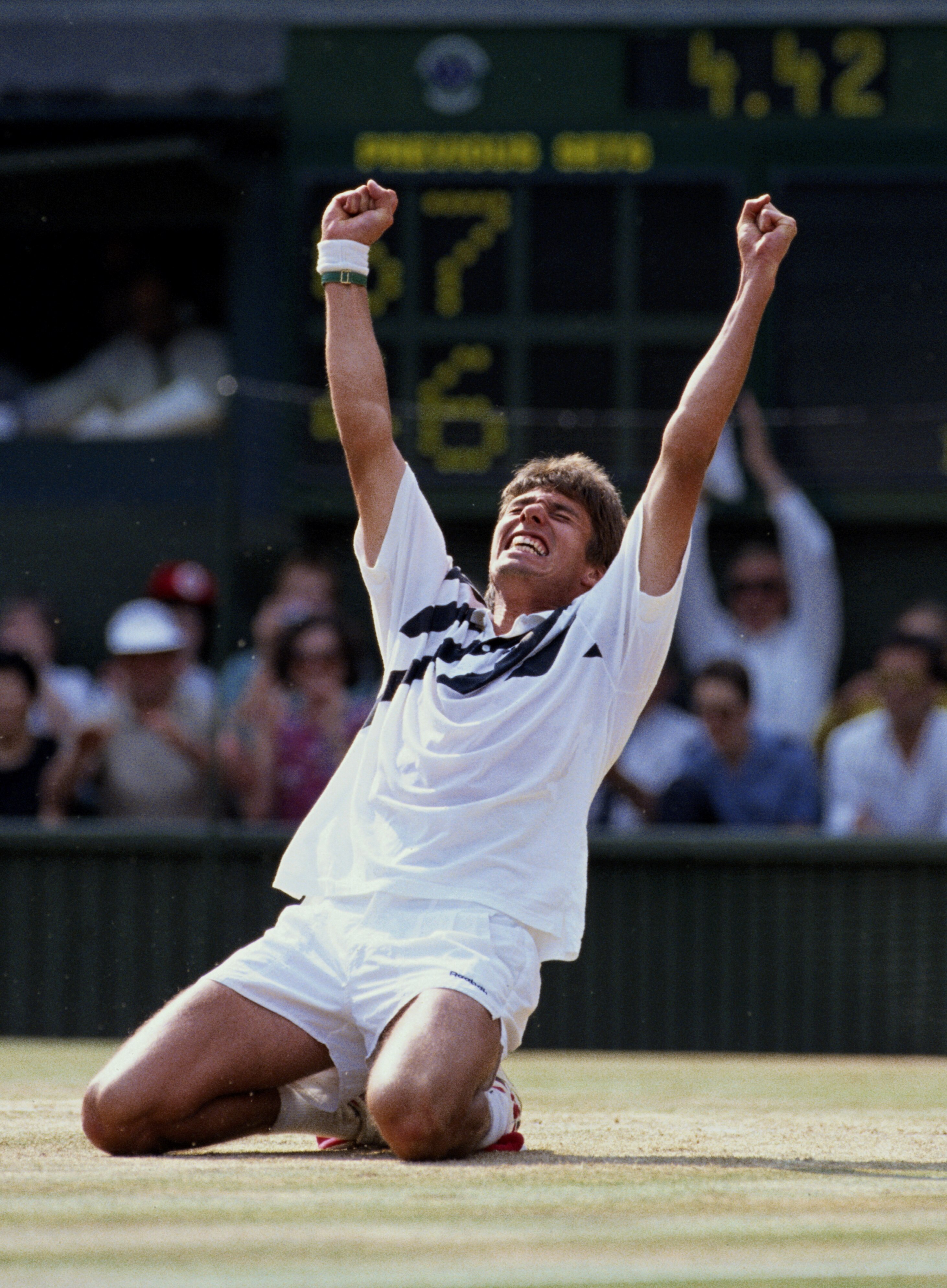 Michael Stich of Germany falls to his knees and raises his arms in triumph to become champion after defeating Boris Becker during their Men's Singles final match at the Wimbledon Lawn Tennis Championship on 7th July 1991 at the All England Lawn Tennis and