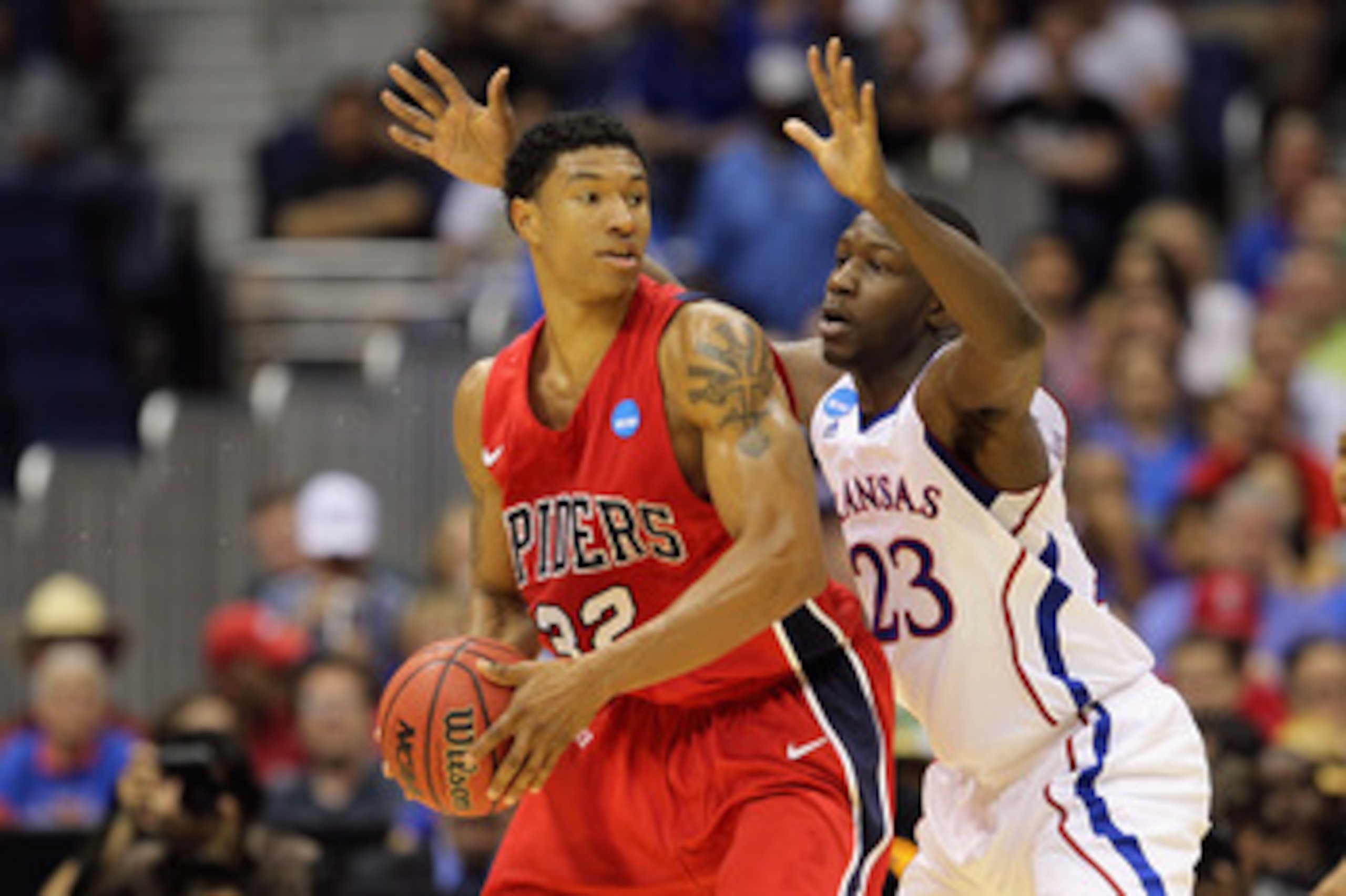 SAN ANTONIO, TX - MARCH 25:  Justin Harper #32 of the Richmond Spiders handles the ball against Mario Little #23 of the Kansas Jayhawks during the southwest regional of the 2011 NCAA men's basketball tournament at the Alamodome on March 25, 2011 in San An