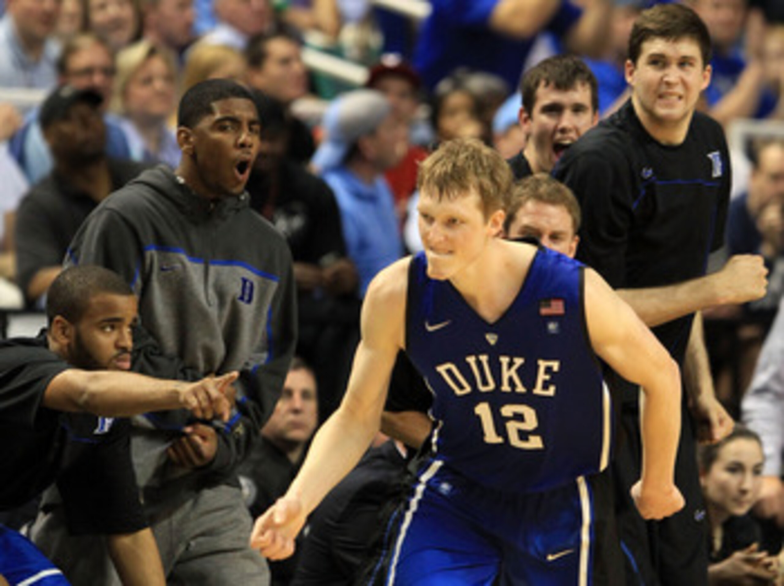 GREENSBORO, NC - MARCH 13:  Kyle Singler #12 of the Duke Blue Devils reacts as teammate Kyrie Irving #1 and the bench cheer him on during the second half of the game against the North Carolina Tar Heels in the championship game of the 2011 ACC men's baske