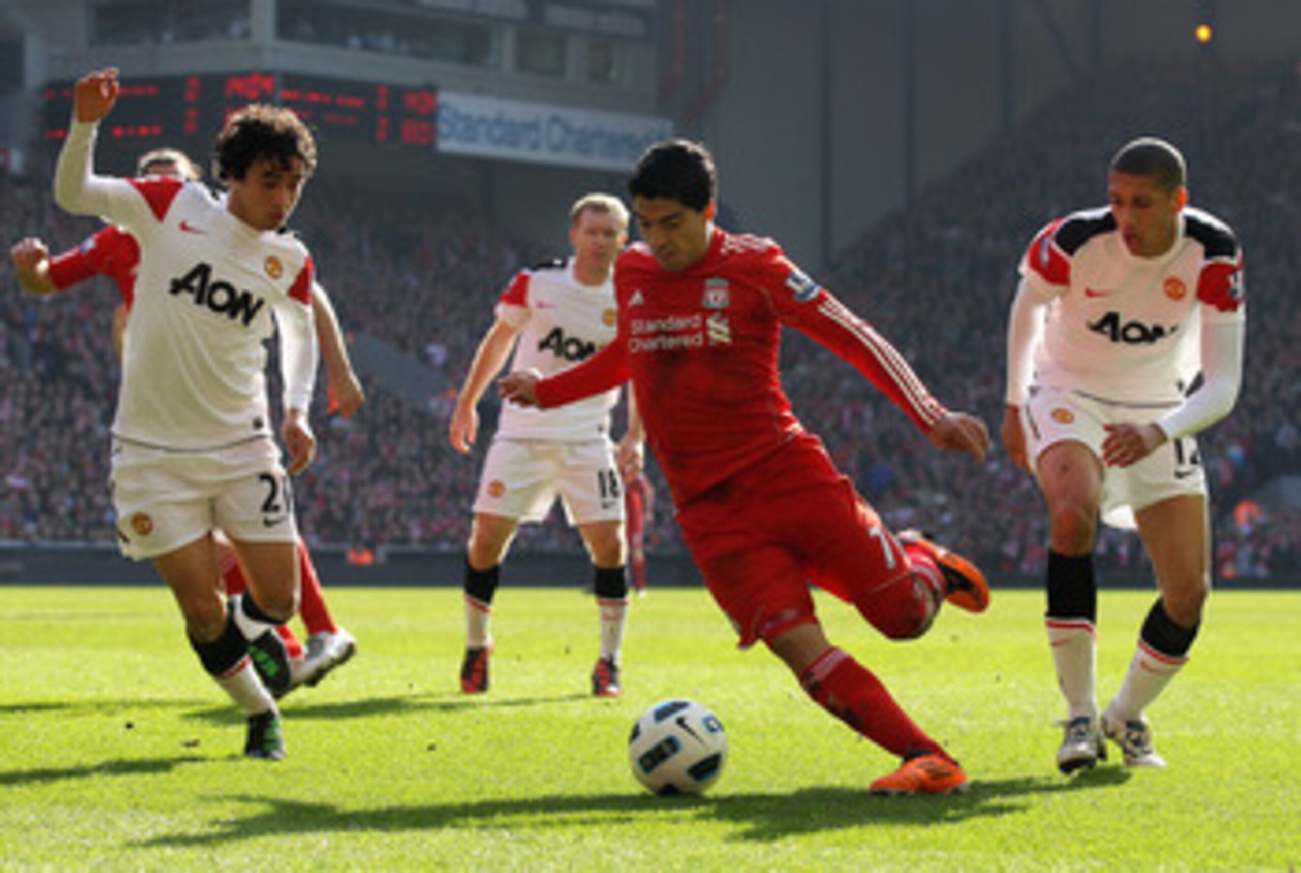 LIVERPOOL, ENGLAND - MARCH 06: Luis Suarez of Liverpool goes clear of Chris Smalling and Rafael (L) of Manchester United to set up the first goal during the Barclays Premier League match between Liverpool and Manchester United at Anfield on March 6, 2011 LIVERPOOL, ENGLAND - MARCH 06: Luis Suarez of Liverpool goes clear of Chris Smalling and Rafael (L) of Manchester United to set up the first goal during the Barclays Premier League match between Liverpool and Manchester United at Anfield on March 6, 2011