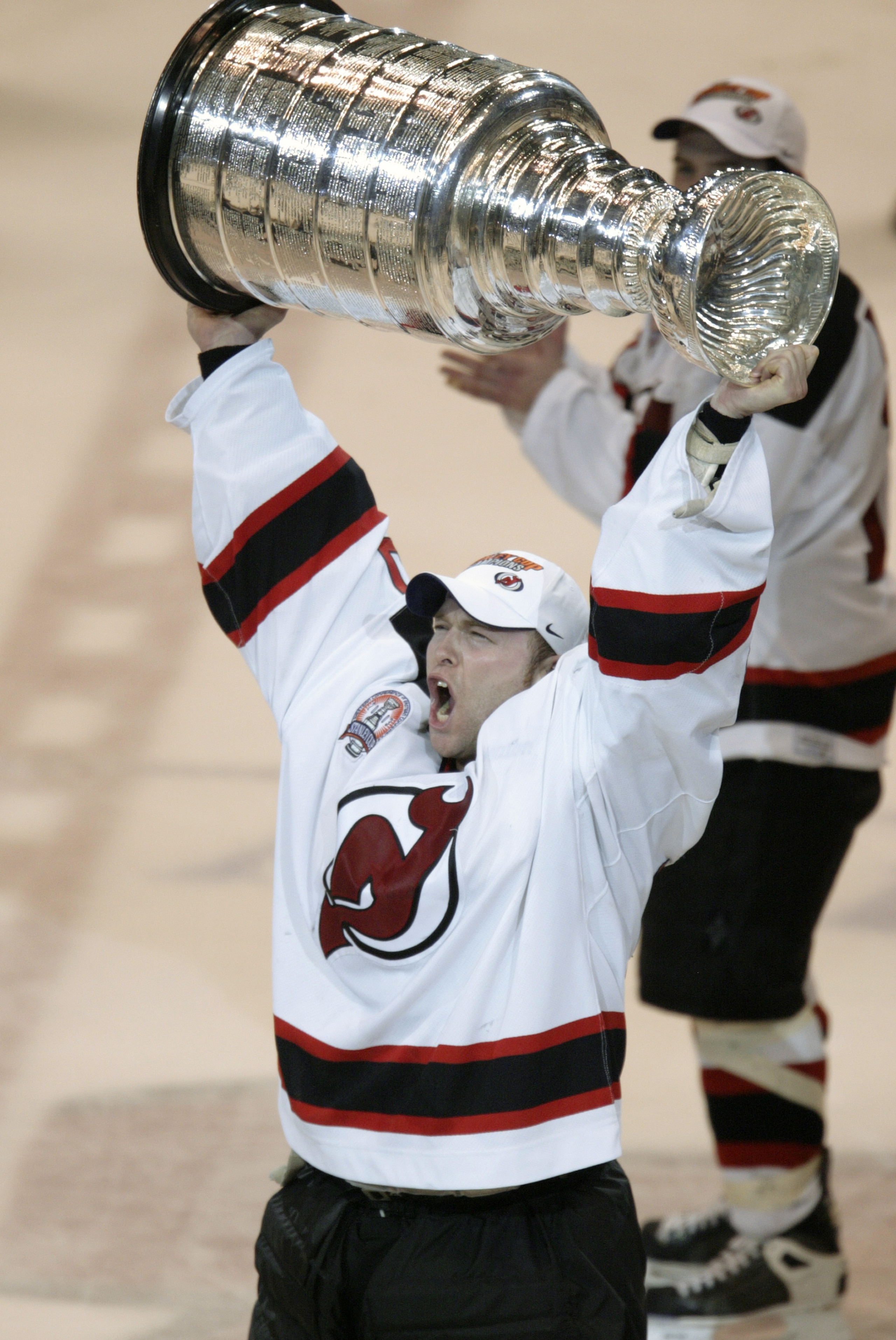 EAST RUTHERFORD, NJ - JUNE 9:  Martin Brodeur #30 of the New Jersey Devils raises the Stanley Cup as he celebrates the win over the Mighty Ducks of Anaheim in game seven of the 2003 Stanley Cup Finals at Continental Airlines Arena on June 9, 2003 in East