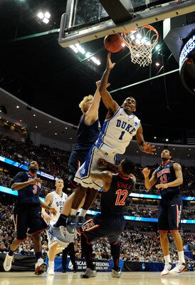 ANAHEIM, CA - MARCH 24:  Kyrie Irving #1 of the Duke Blue Devils draws contact against Kyryl Natyazhko #1 and Lamont Jones #12 of the Arizona Wildcats during the west regional semifinal of the 2011 NCAA men's basketball tournament at the Honda Center on M