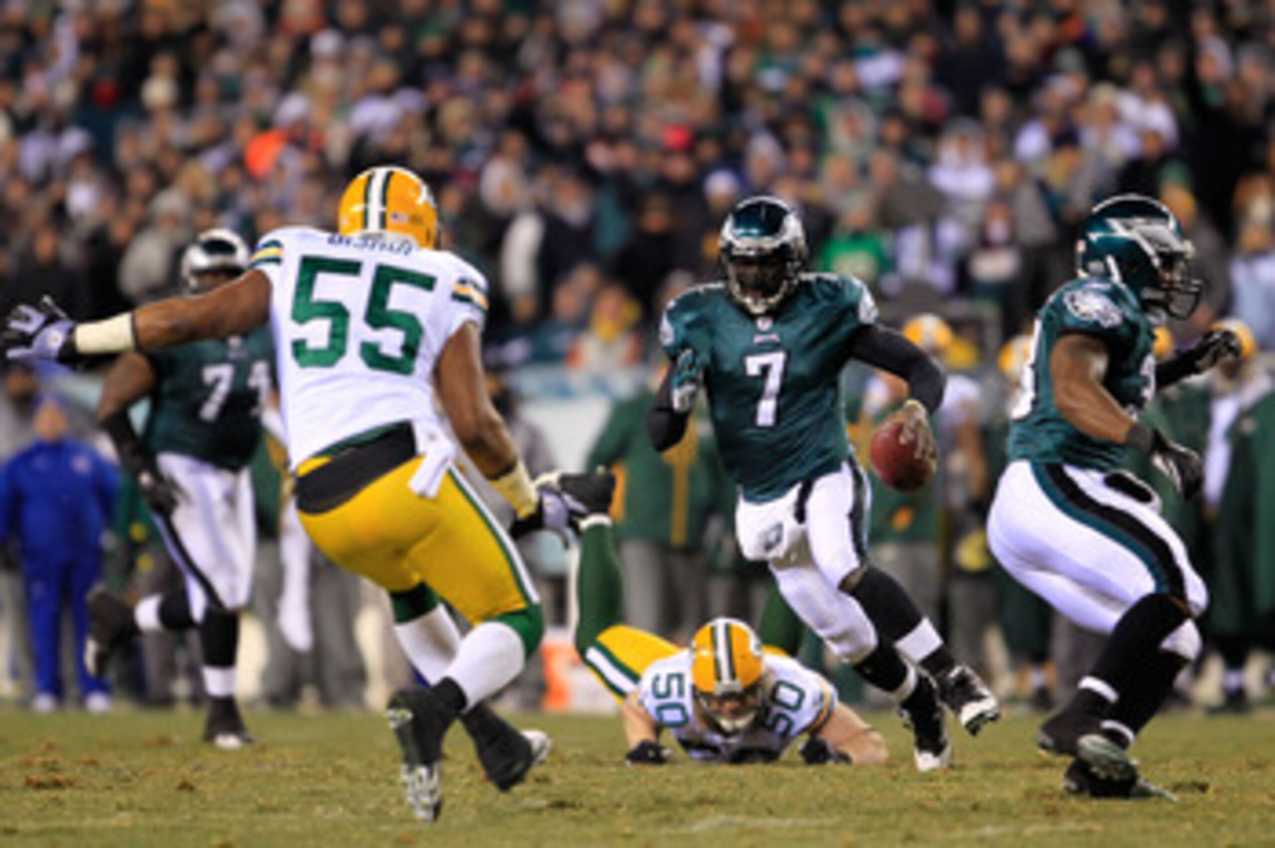 PHILADELPHIA, PA - JANUARY 09:  Michael Vick #7 of the Philadelphia Eagles scrambles against A.J. Hawk #50 and Desmond Bishop #55 of the Green Bay Packers during the 2011 NFC wild card playoff game at Lincoln Financial Field on January 9, 2011 in Philadel