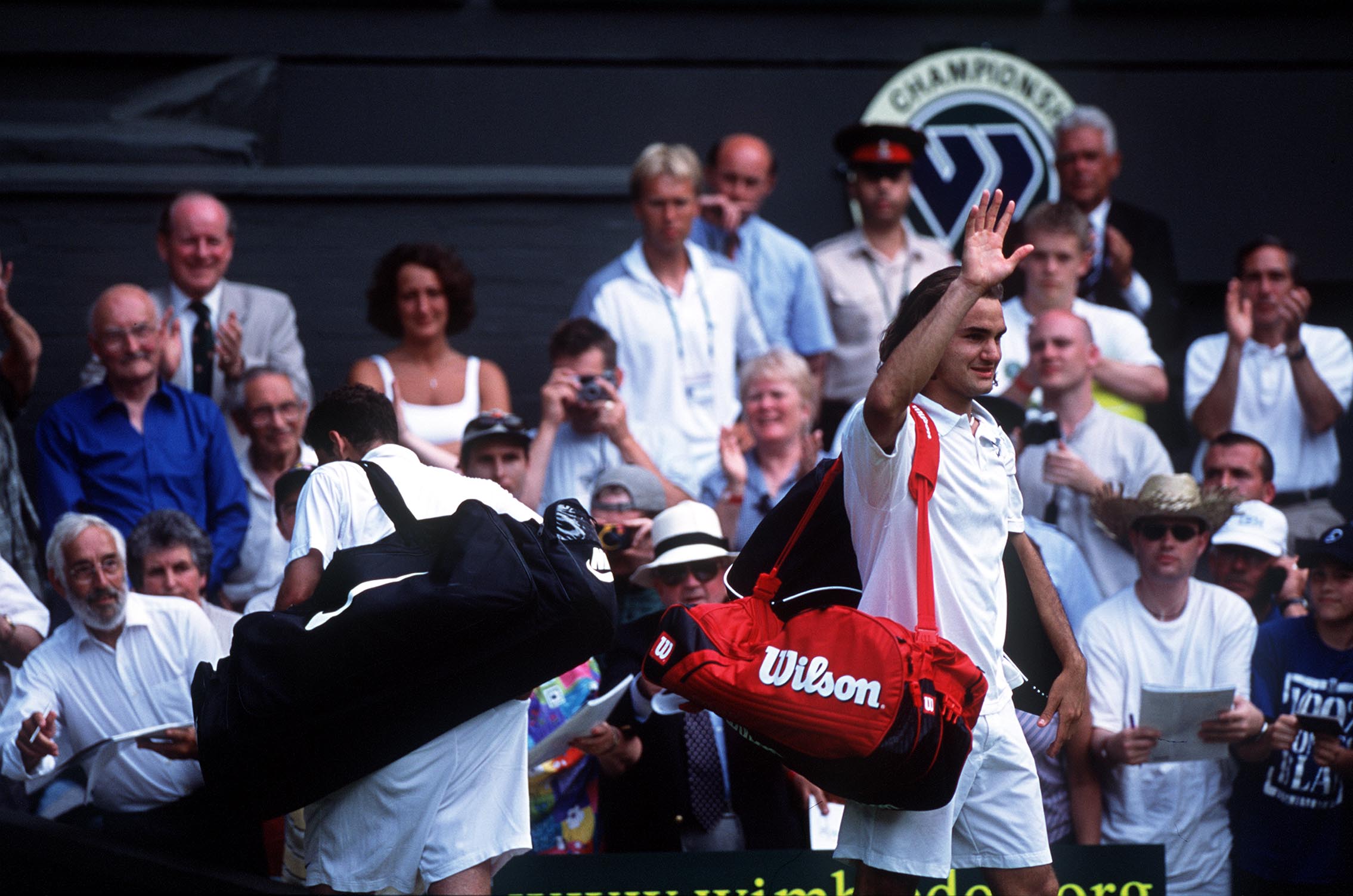 2 Jul 2001:  Roger Federer (right) of Switzerland salutes the fans as Pete Sampras of the USA walks off court during the men's fourth round of The All England Lawn Tennis Championship at Wimbledon, London.  DIGITAL IMAGE Mandatory Credit: Clive Brunskill/