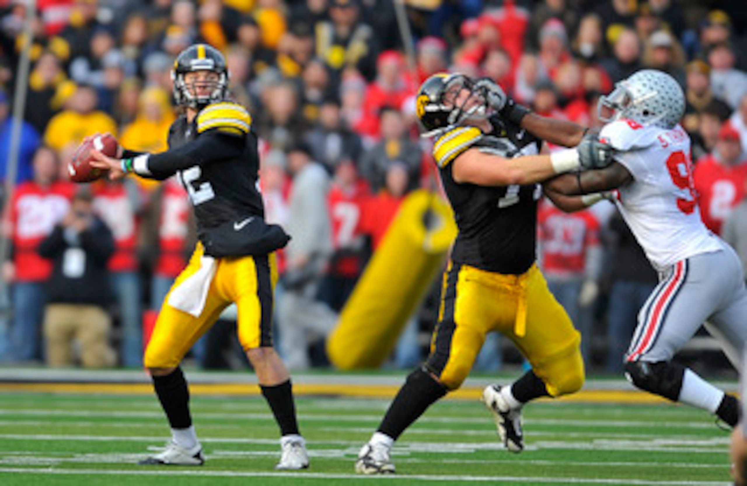 IOWA CITY, IA - NOVEMBER 20:  Quarterback Ricky Stanzi #12 of the University of Iowa Hawkeyes throws under pressure from defensive lineman Solomon Thomas #98 of the Ohio State Buckeyes as offensive lineman Riley Reiff #77 defends during the first half of 