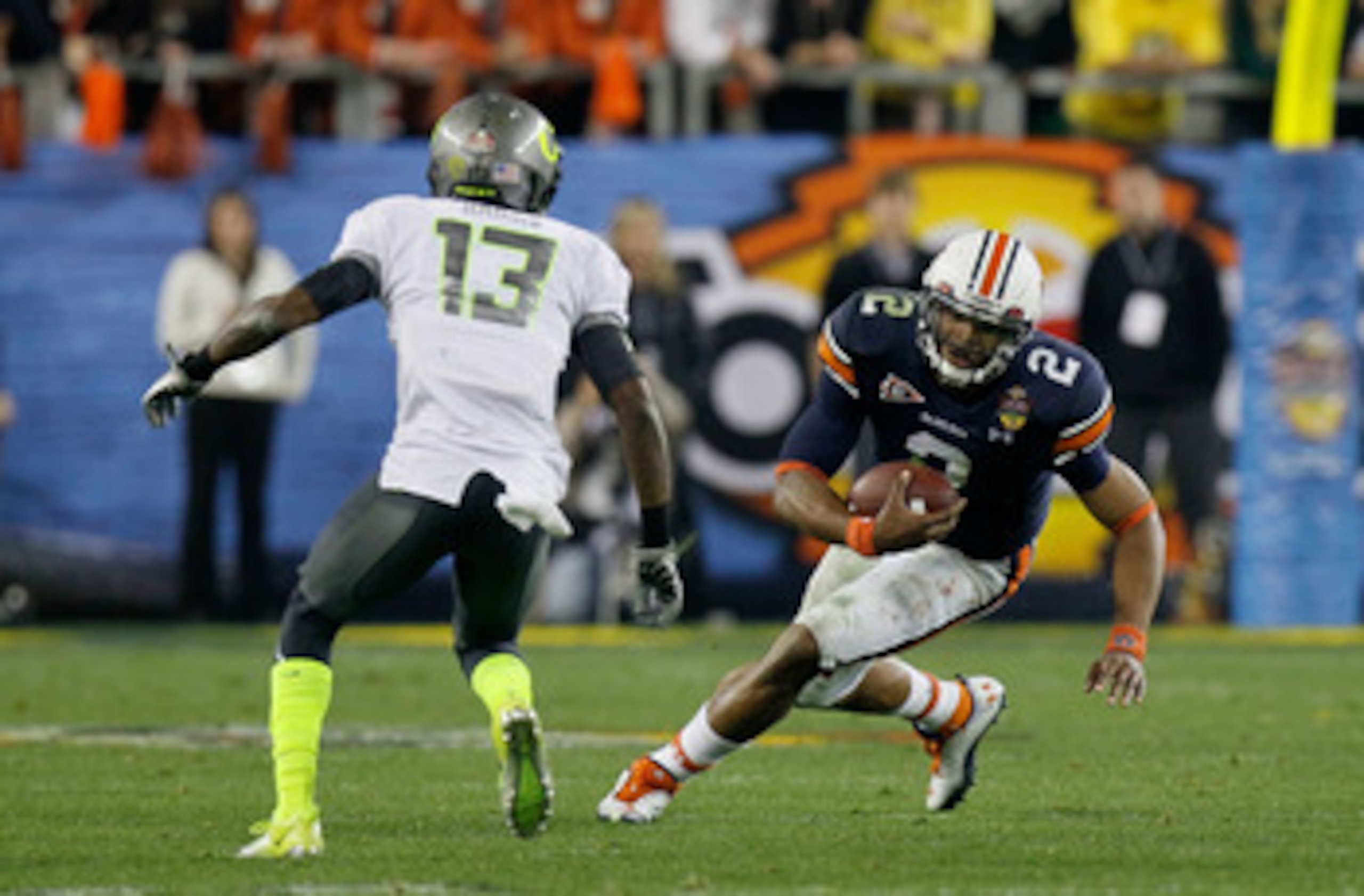 GLENDALE, AZ - JANUARY 10:  Cameron Newton #2 of the Auburn Tigers runs down field against Cliff Harris #13 of the Oregon Ducks during the Tostitos BCS National Championship Game at University of Phoenix Stadium on January 10, 2011 in Glendale, Arizona.  