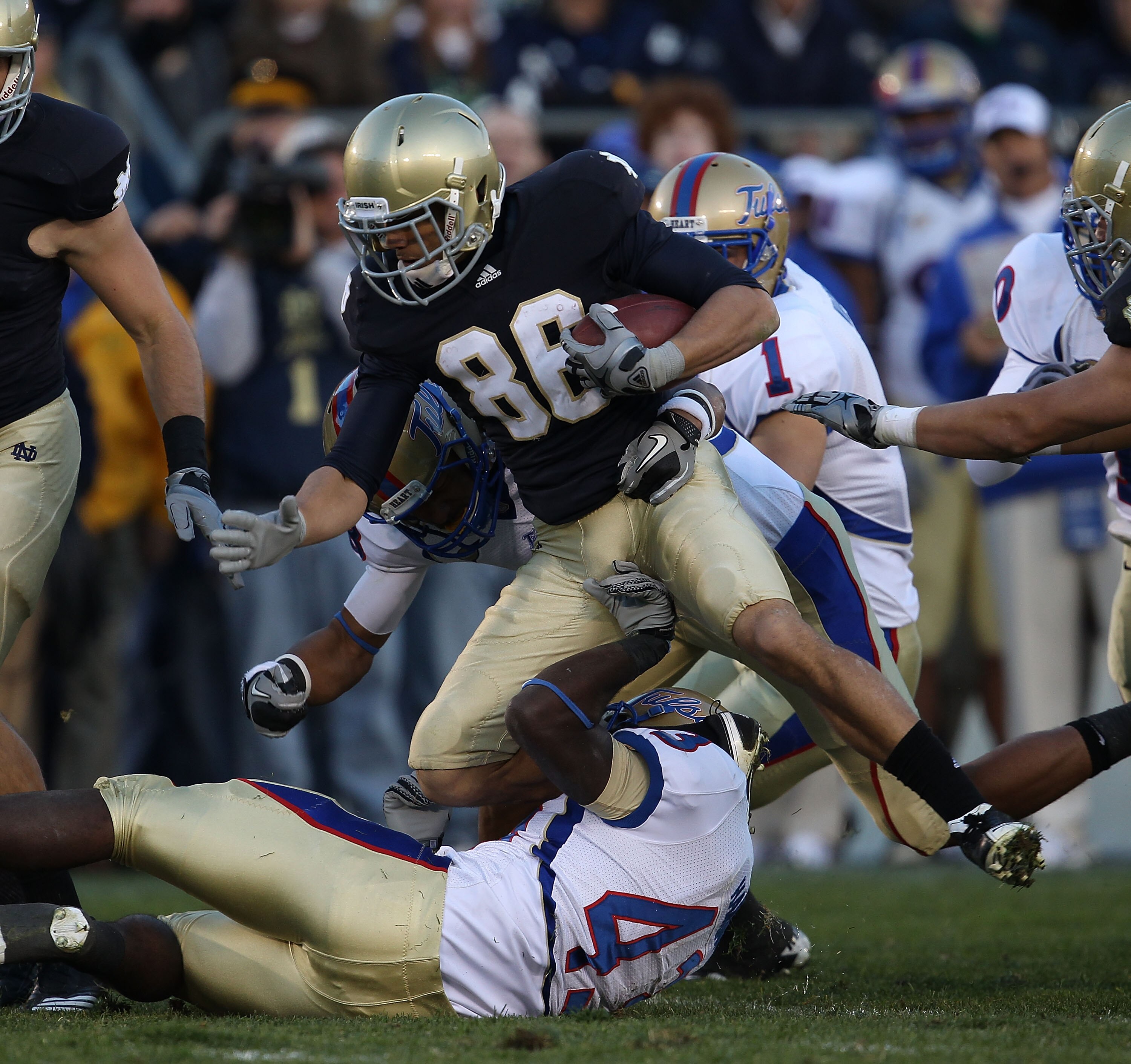 SOUTH BEND, IN - OCTOBER 30: Bennett Jackson #86 of the Notre Dame Fighting Irish is tackled by Donnell Hawkins #43 and Bryan Burnham #88 of the Tulsa Golden Hurricane at Notre Dame Stadium on October 30, 2010 in South Bend, Indiana. Tulsa defeated Notre SOUTH BEND, IN - OCTOBER 30: Bennett Jackson #86 of the Notre Dame Fighting Irish is tackled by Donnell Hawkins #43 and Bryan Burnham #88 of the Tulsa Golden Hurricane at Notre Dame Stadium on October 30, 2010 in South Bend, Indiana. Tulsa defeated Notre